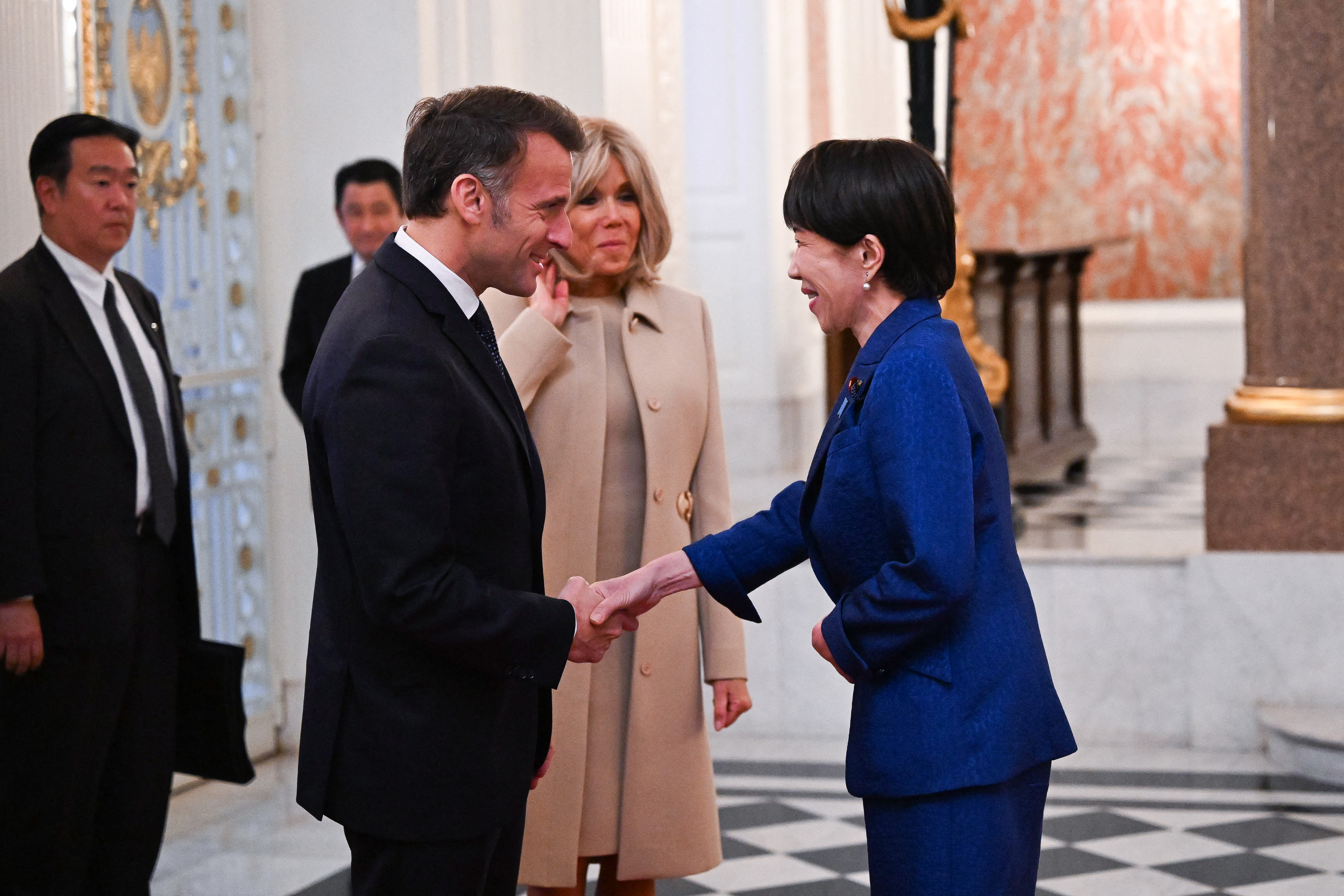Le président français Emmanuel Macron (à gauche) et la première dame Brigitte Macron (au centre) rencontrent la Première ministre japonaise Sanae Takaichi lors d'une cérémonie de bienvenue au palais d'Akasaka à Tokyo, au Japon, le 1er avril 2026 I Source : Getty Images