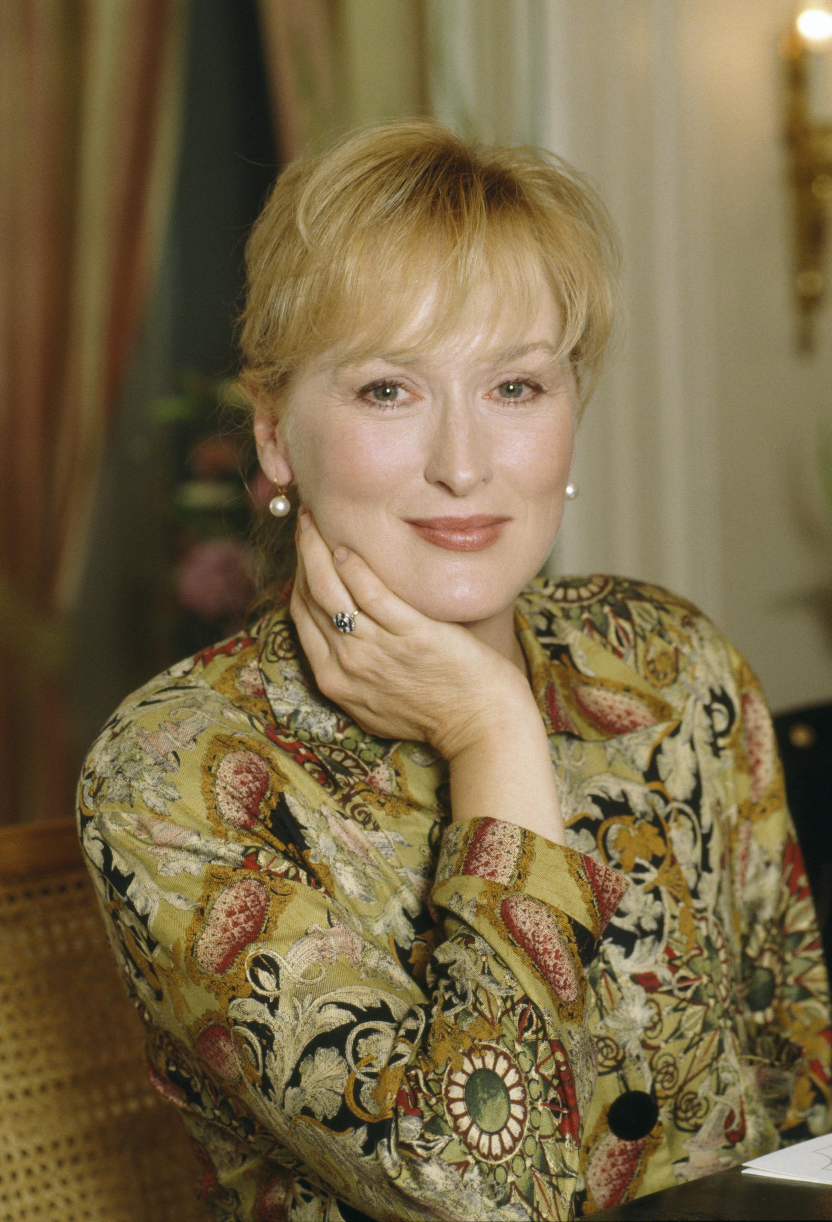 On voit ici Meryl Streep sur un portrait pris en 1992, vêtue d'un chemisier à motifs et la main posée sur son visage | Source : Getty Images