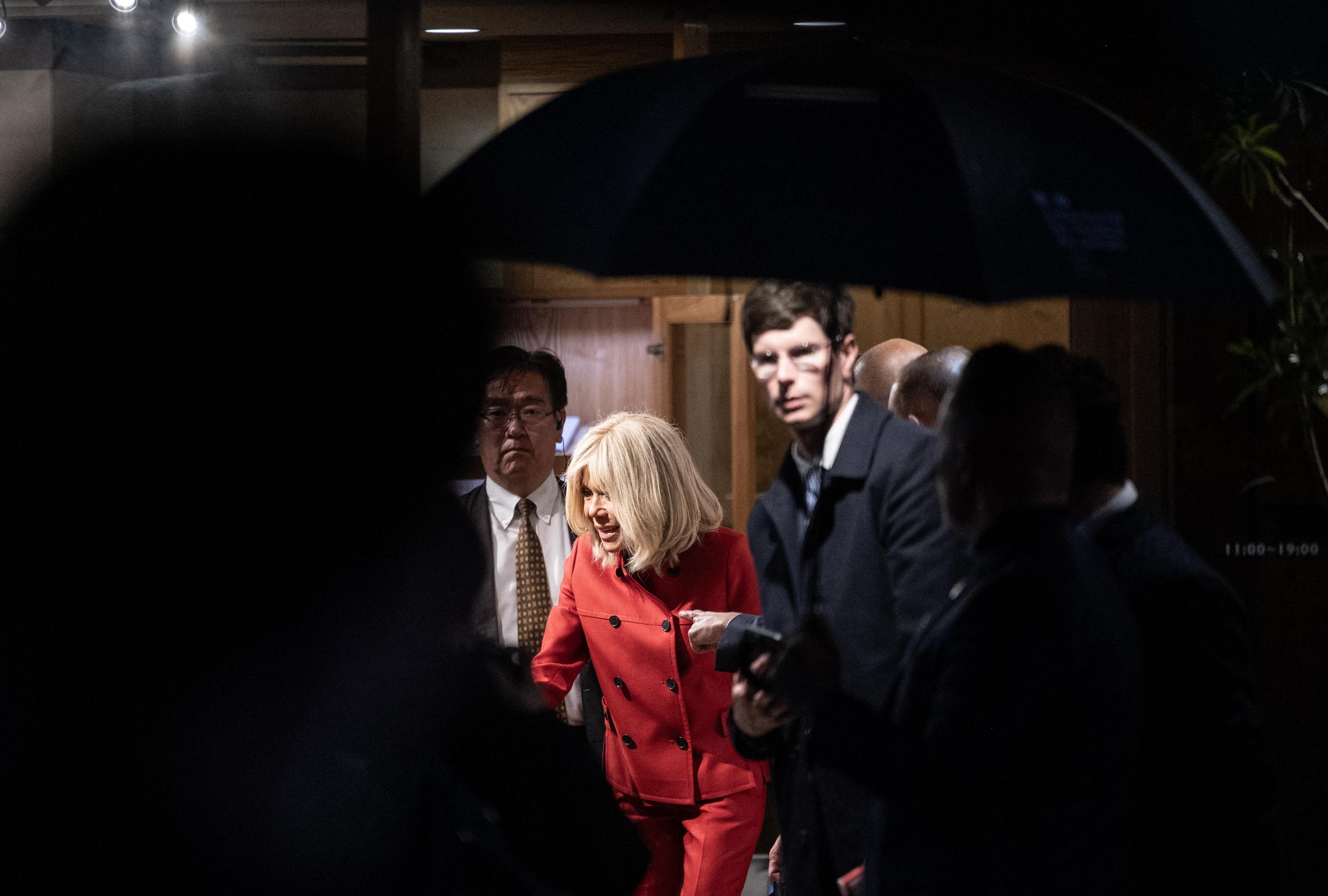 Le président français Emmanuel Macron et son épouse Brigitte Macron quittent le showroom Ginza Motoji par une nuit pluvieuse à Tokyo, le 31 mars 2026 I Source : Getty Images
