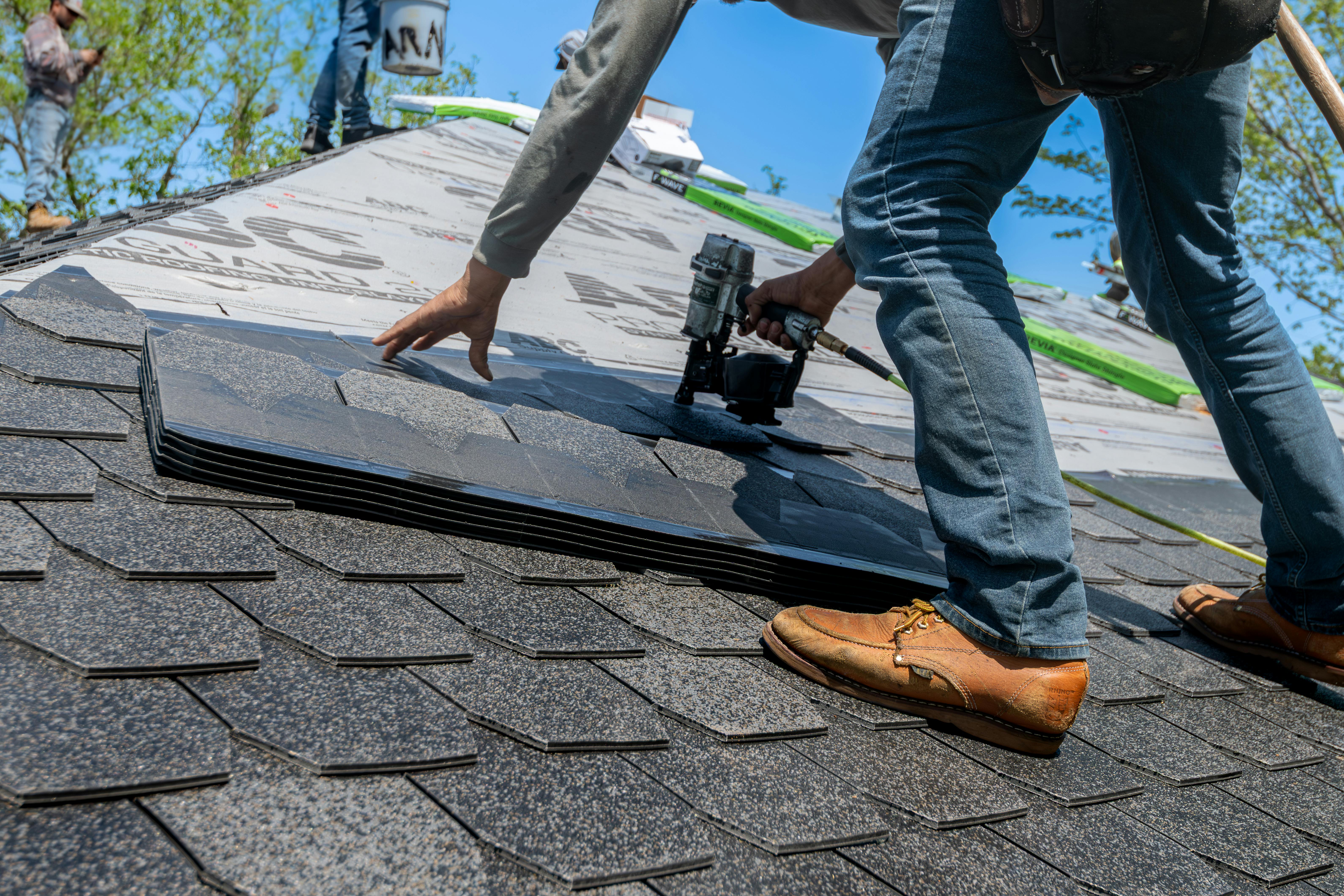 Un homme installe de nouveaux bardeaux sur un toit | Source : Pexels