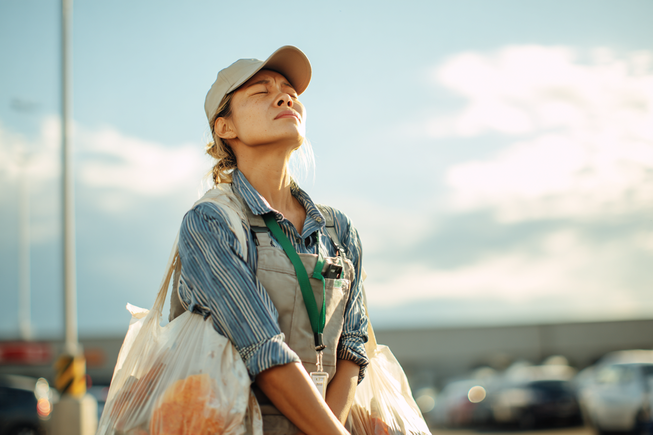Une femme dans un parking transportant des sacs de provisions | Source : Midjourney