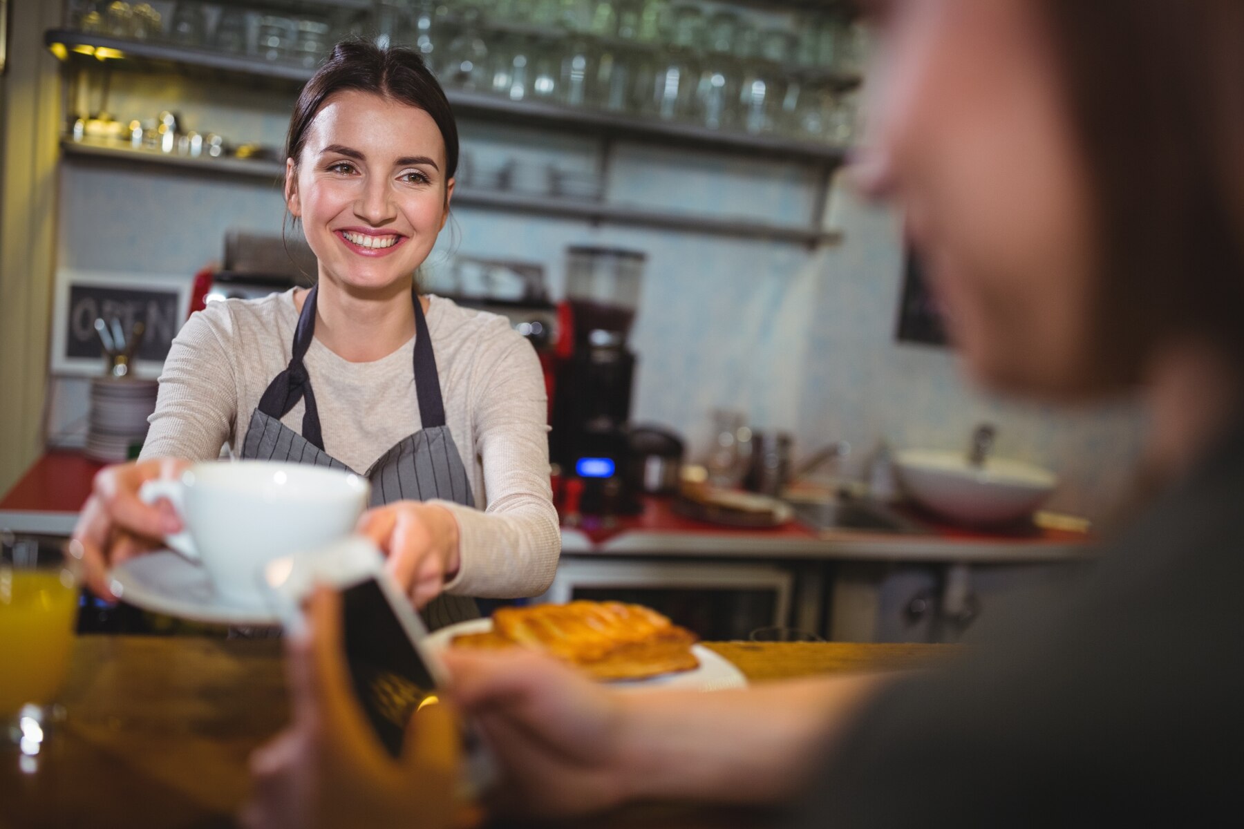 Une serveuse donnant sa commande à une personne | Source : FreePik
