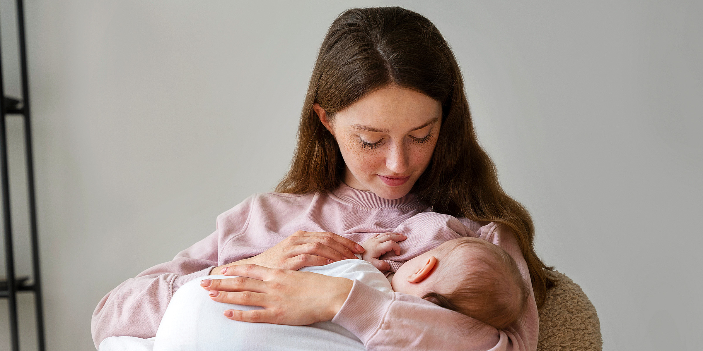 Une jeune femme nourrit son bébé | Source : Freepik