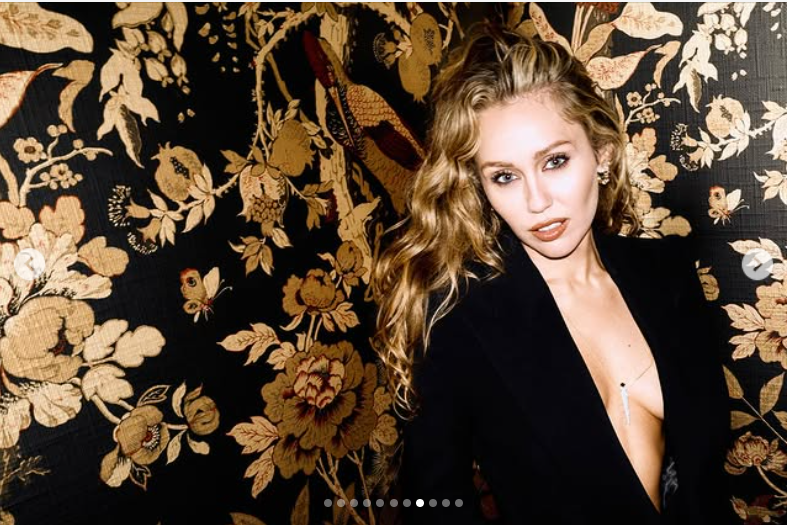 Miley Cyrus pose avec assurance devant un décor floral somptueux, comme le montre sa publication datée du 25 octobre 2025 | Source : Instagram/mileycyrus