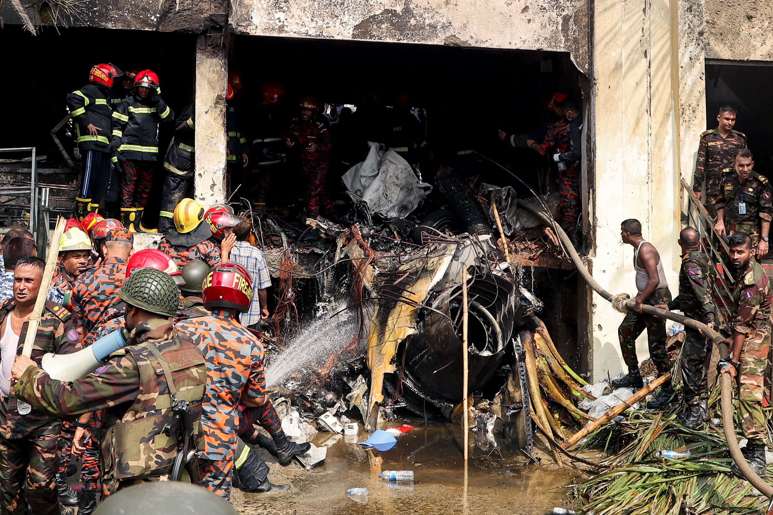 Les pompiers et le personnel de sécurité du Bangladesh mènent une opération de recherche et de sauvetage après qu'un avion d'entraînement de l'armée de l'air s'est écrasé sur l'école et le collège Milestone à Dhaka, le 21 juillet 2025 | Source : Getty Images