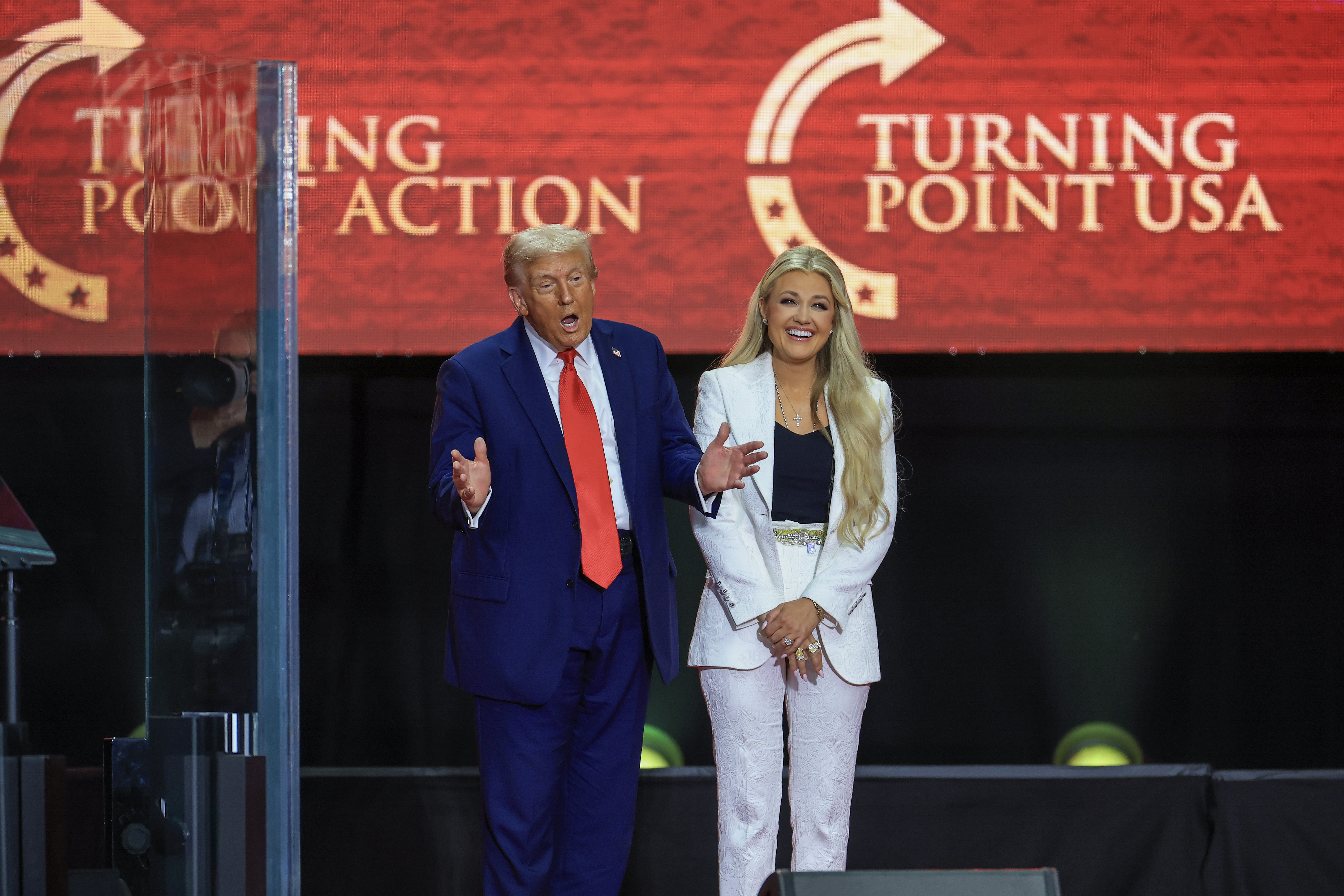 Le président américain Donald Trump s'exprimant tandis qu'Erika Kirk sourit à ses côtés. | Source : Getty Images