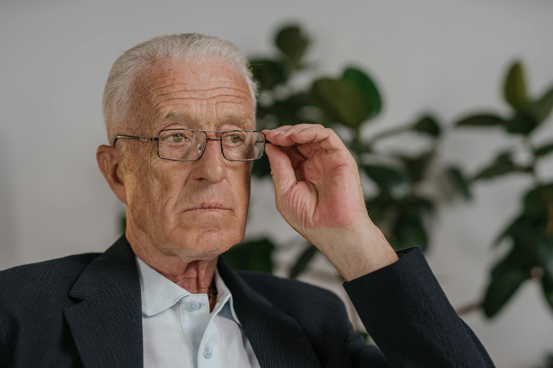Un homme âgé tenant ses lunettes | Source : Pexels
