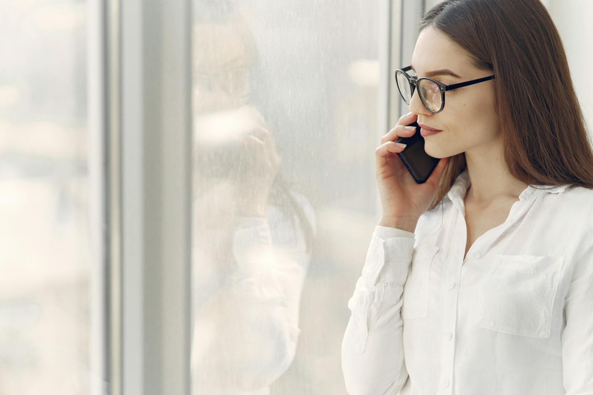Une femme souriant d'un air maussade pendant un appel téléphonique | Source : Pexels