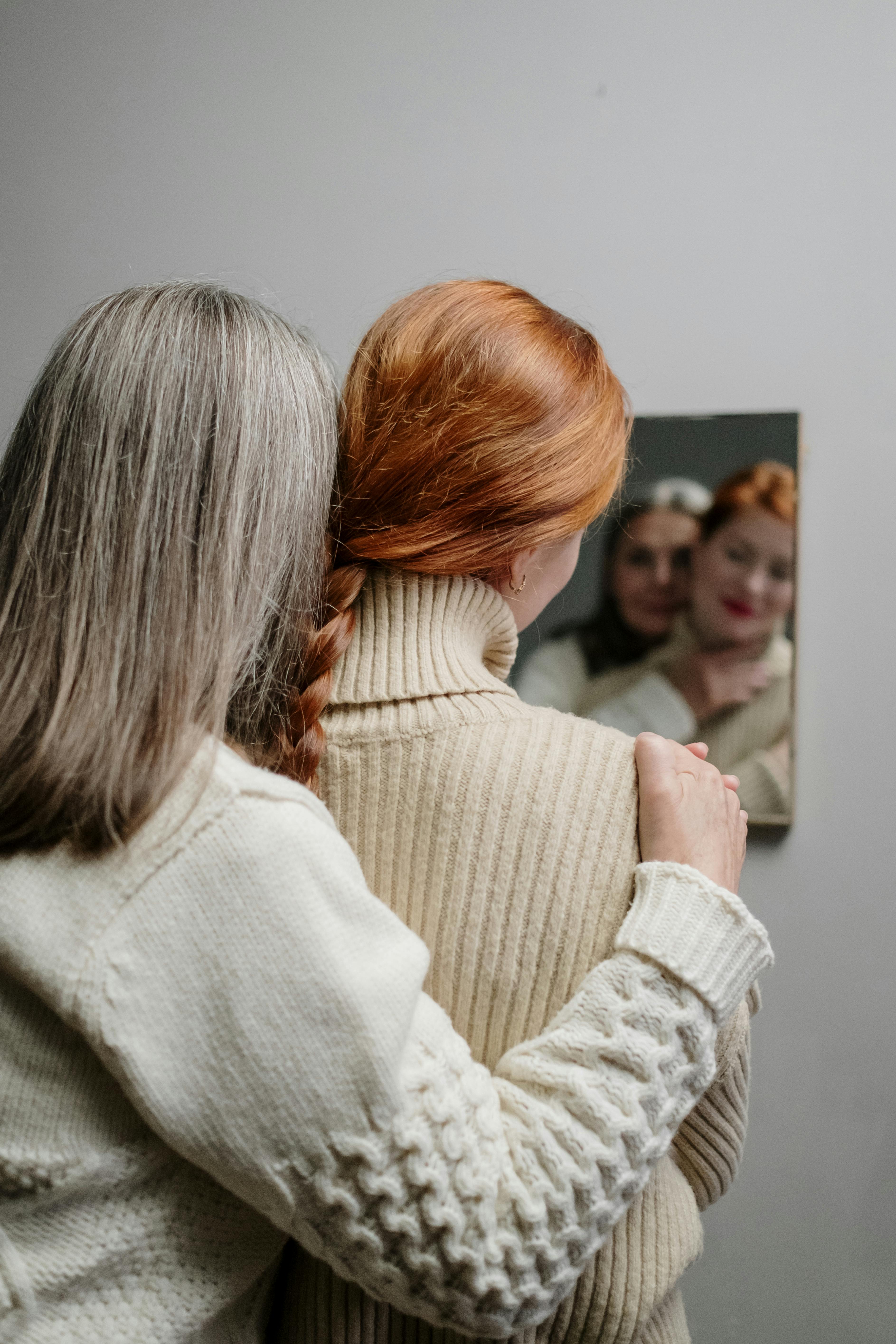 Une femme plus âgée embrassant une plus jeune tout en se regardant dans le miroir | Source : Pexels