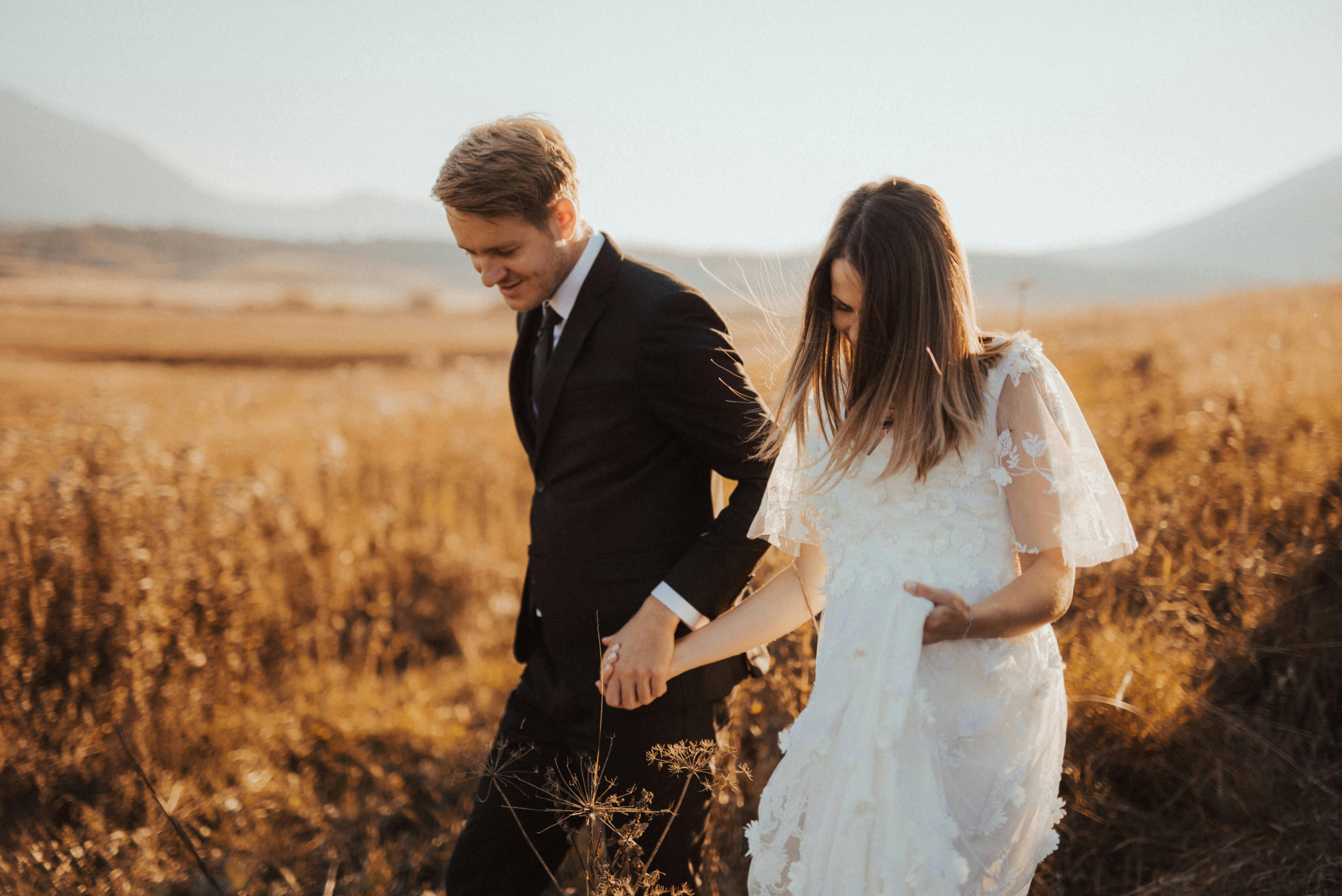 Un couple de mariés dans un champ | Source : Pexels