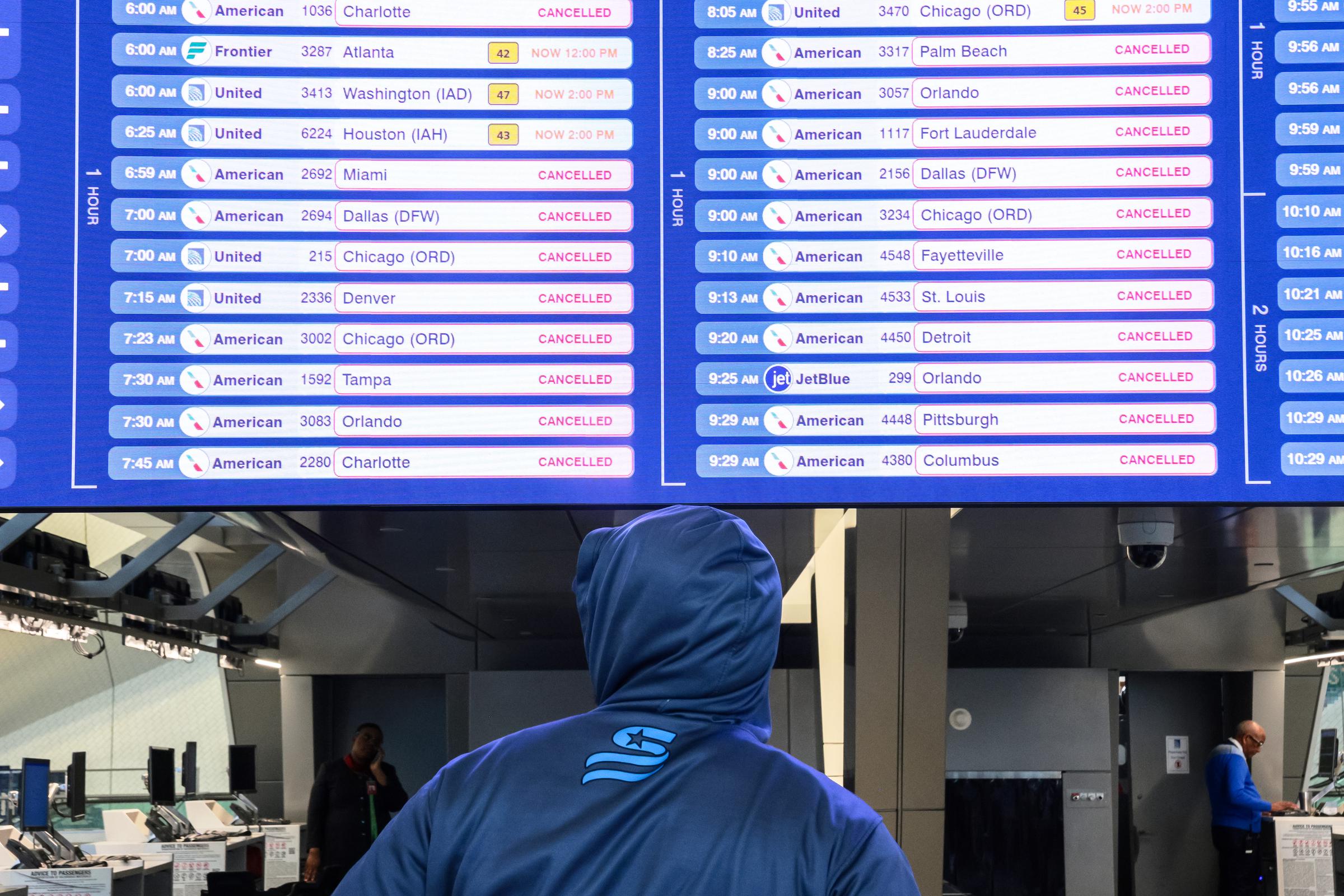 Un voyageur consulte la liste des vols annulés sur un écran au terminal B de l'aéroport LaGuardia à New York, le 23 mars 2026. | Source : Getty Images