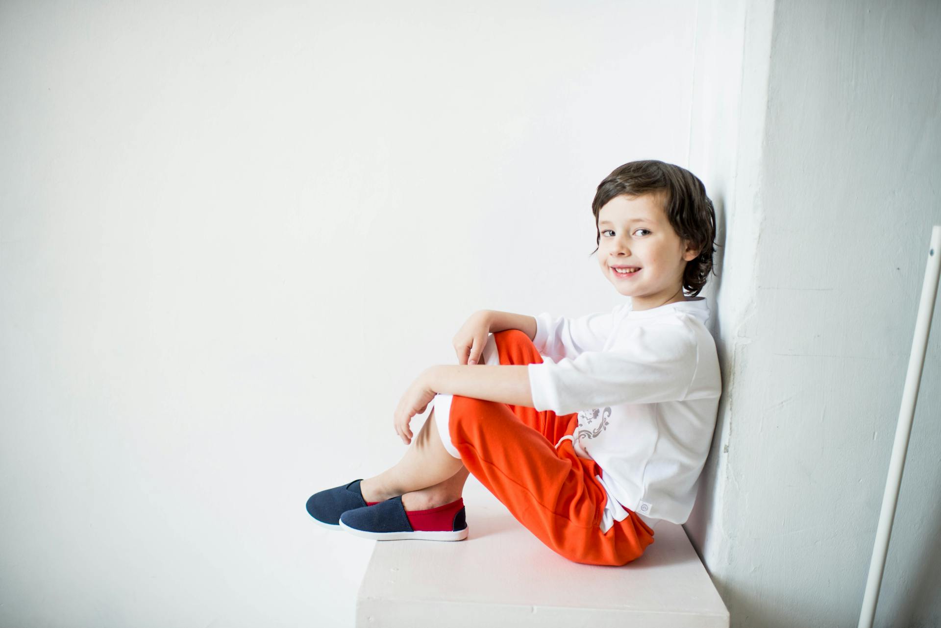 Un jeune garçon adossé à un mur | Source : Pexels
