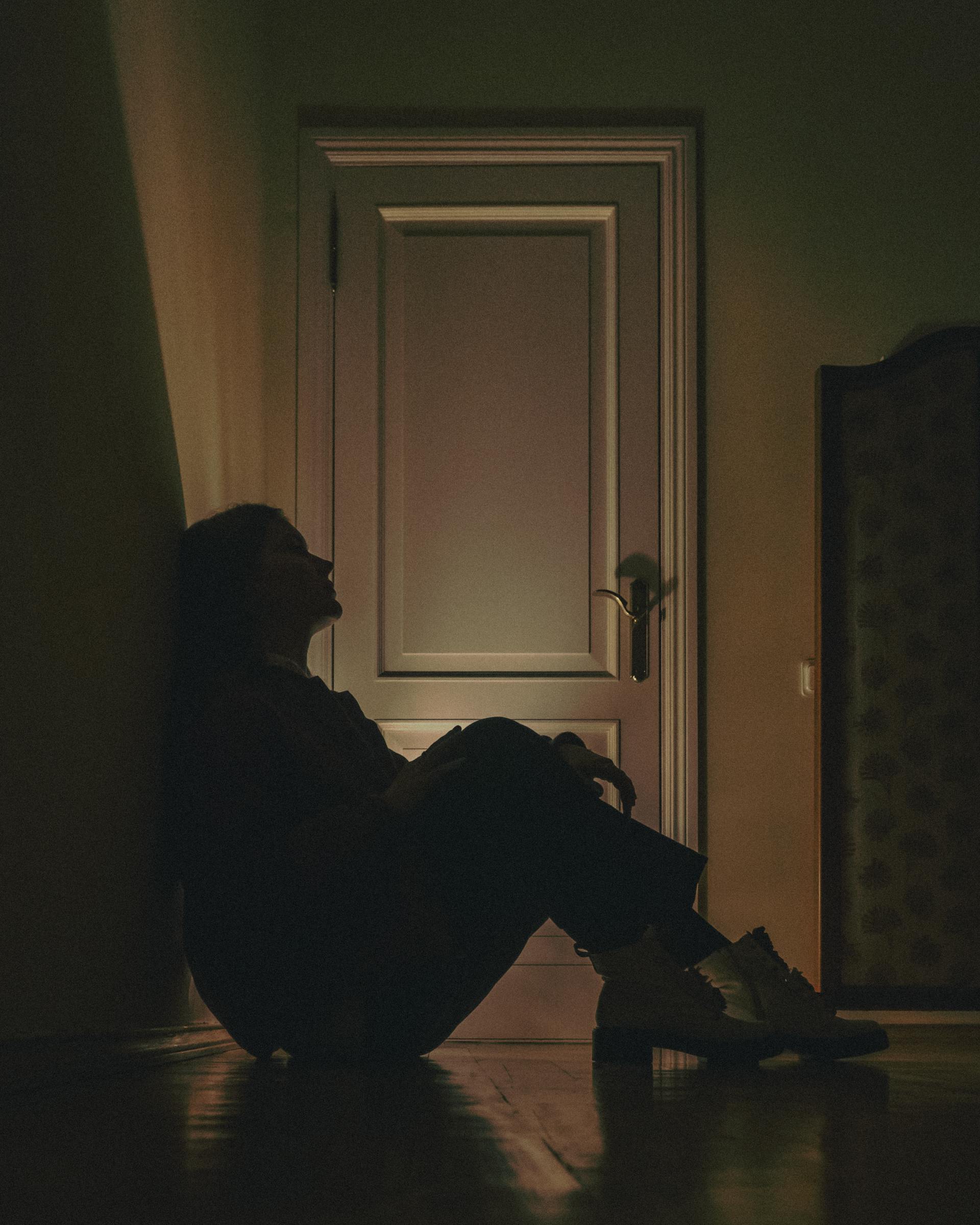 Une femme assise par terre et adossée au mur | Source : Pexels