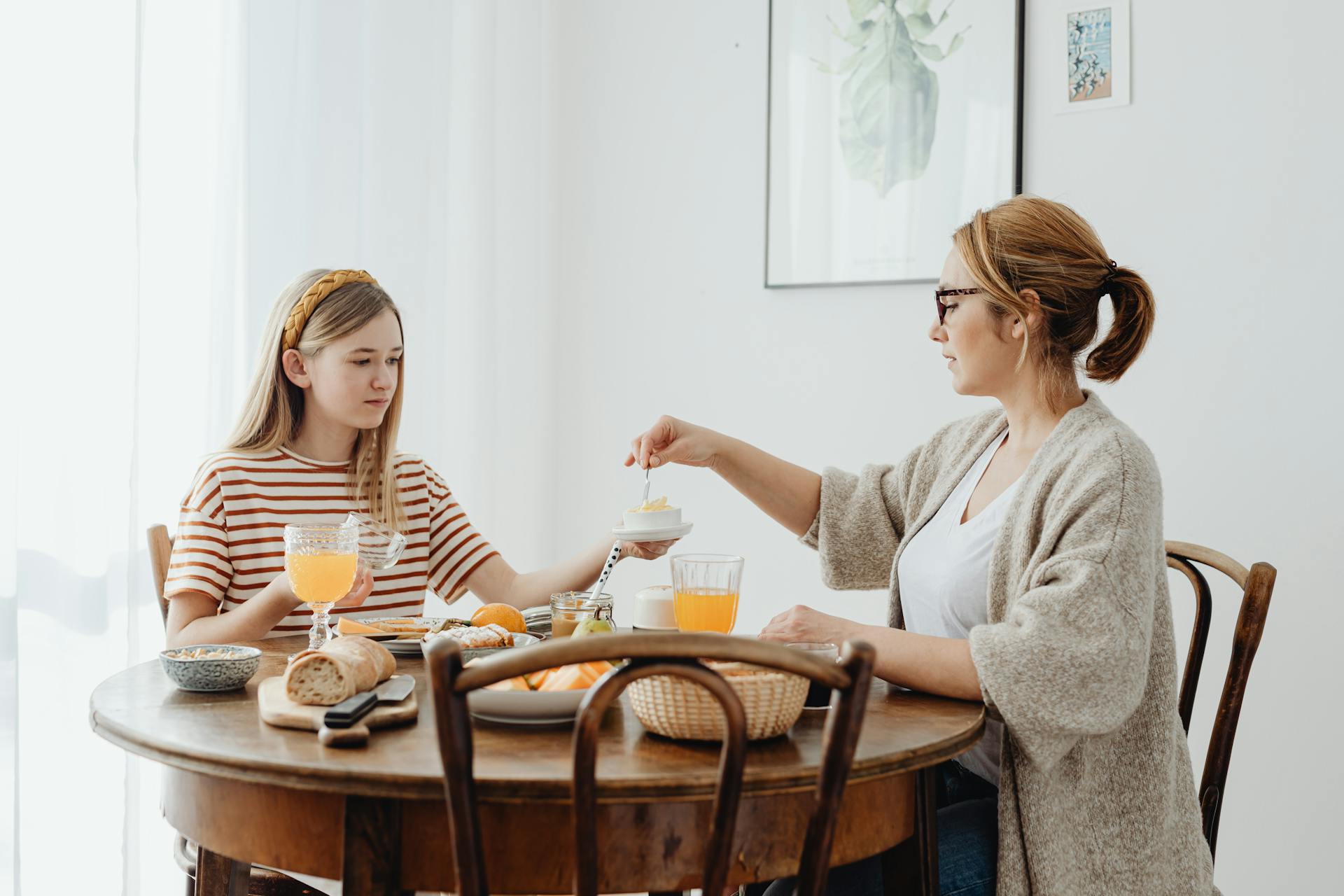 Une femme et une adolescente assises à la table à manger | Source : Pexels