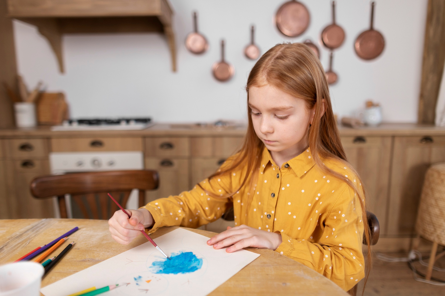 Une fille qui peint sur une feuille de papier | Source : Freepik