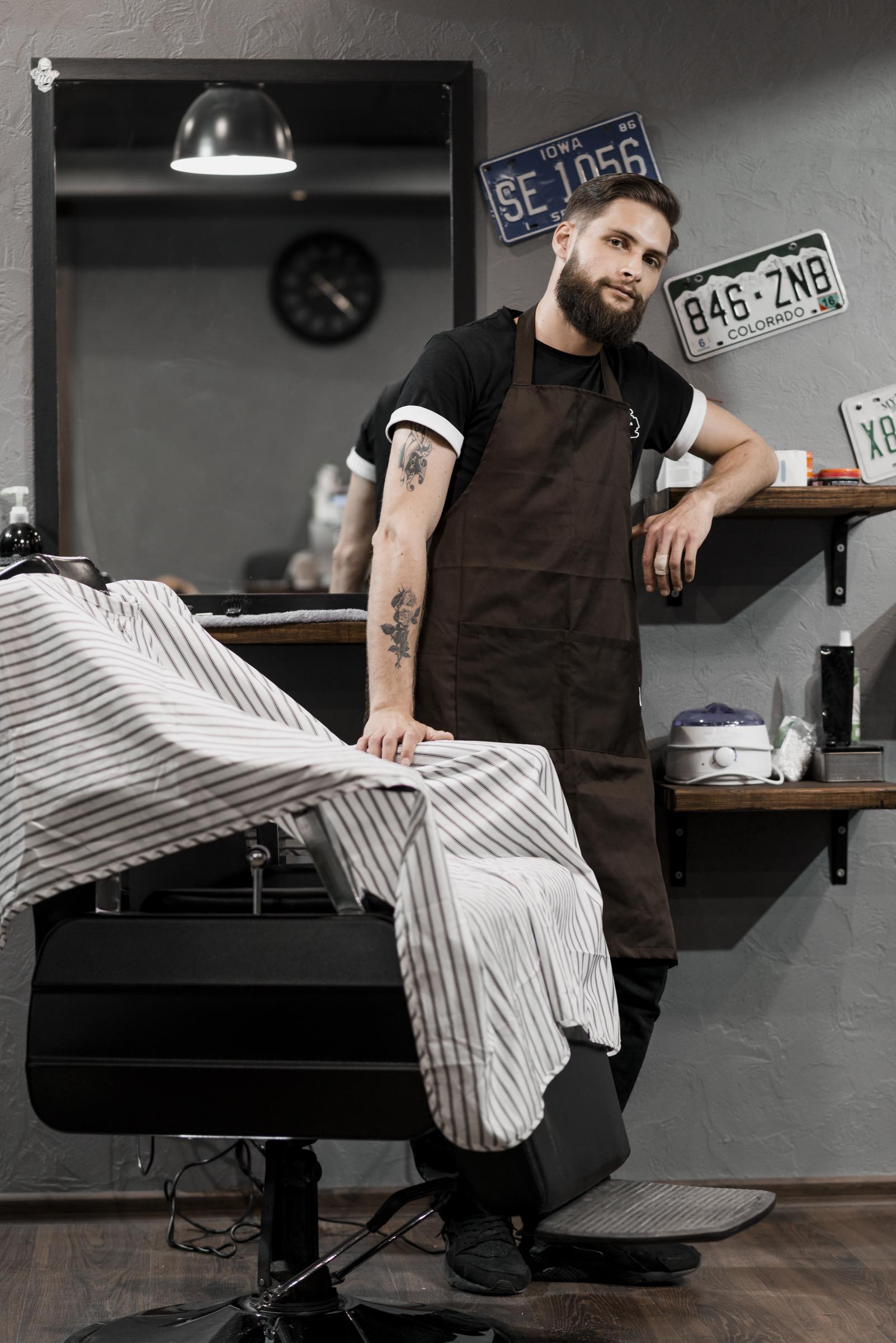Un coiffeur debout dans un salon de coiffure | Source : Freepik