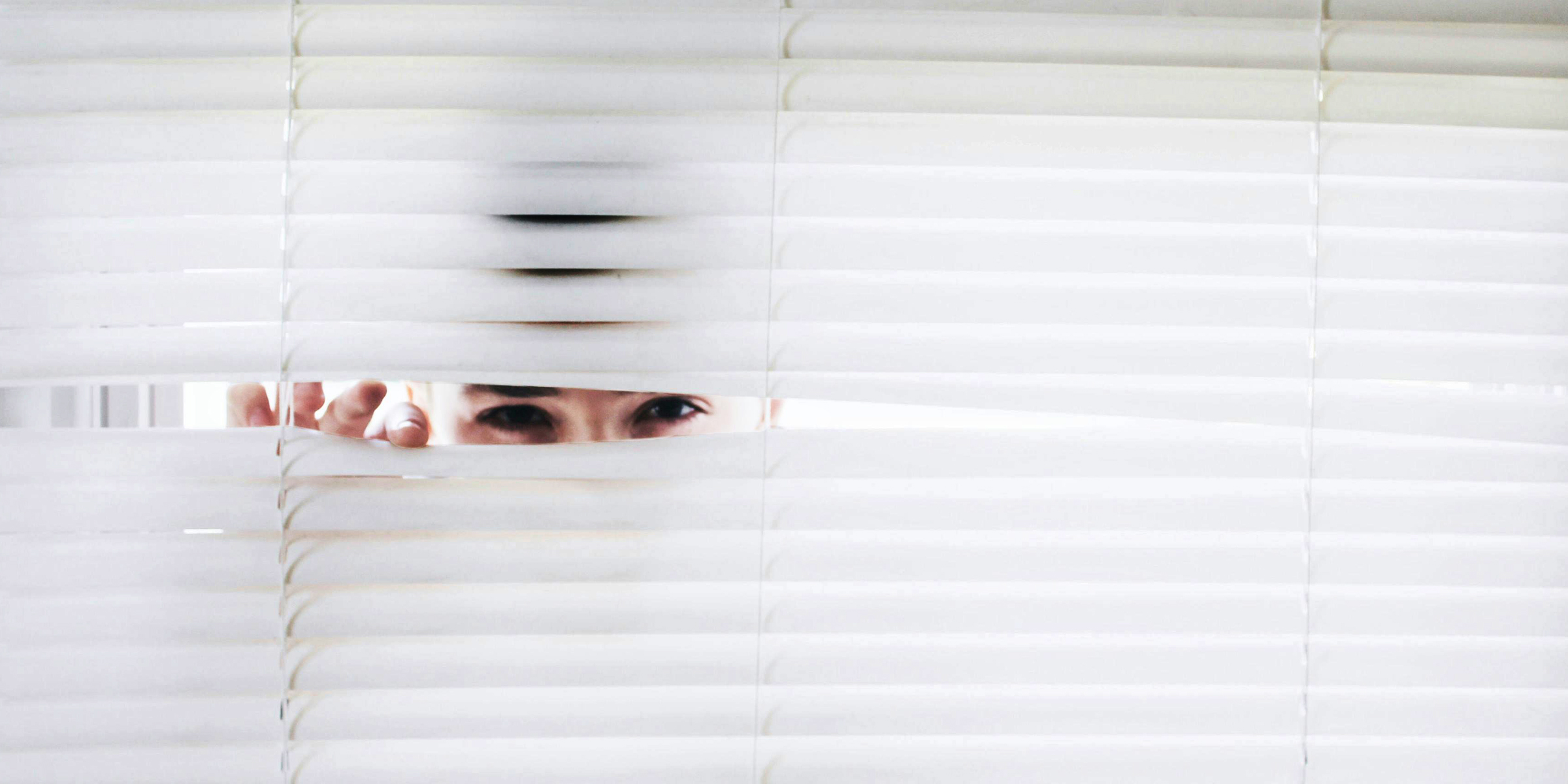 Un homme qui regarde à travers les stores de la fenêtre | Source : Pexels