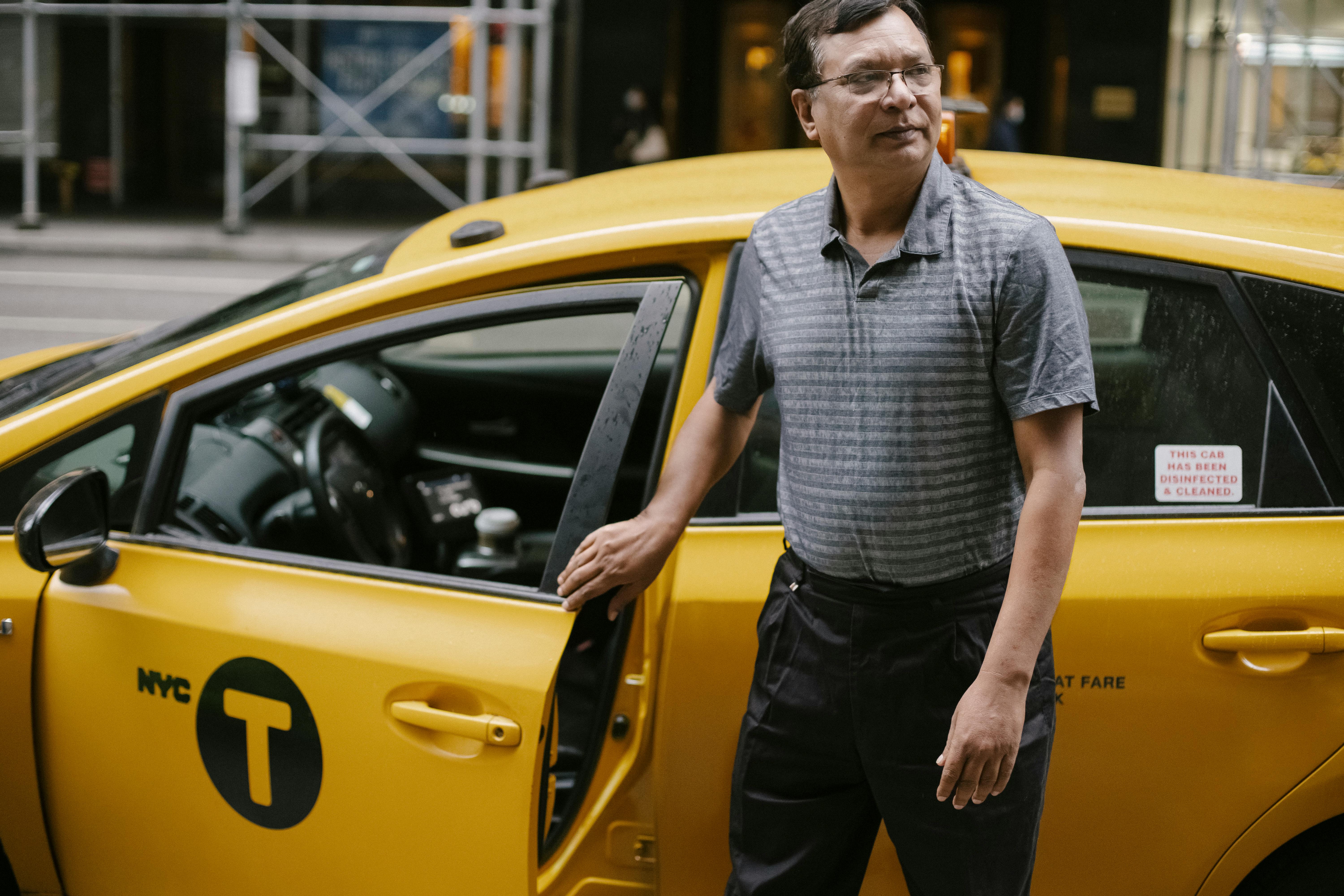 Un chauffeur de taxi debout à côté de sa voiture | Source : Unsplash