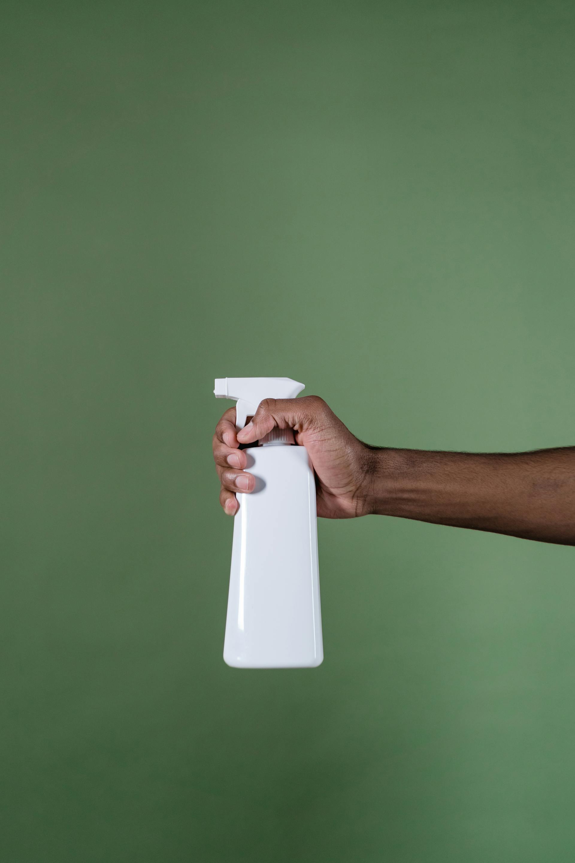 Un homme tenant un flacon pulvérisateur | Source : Pexels