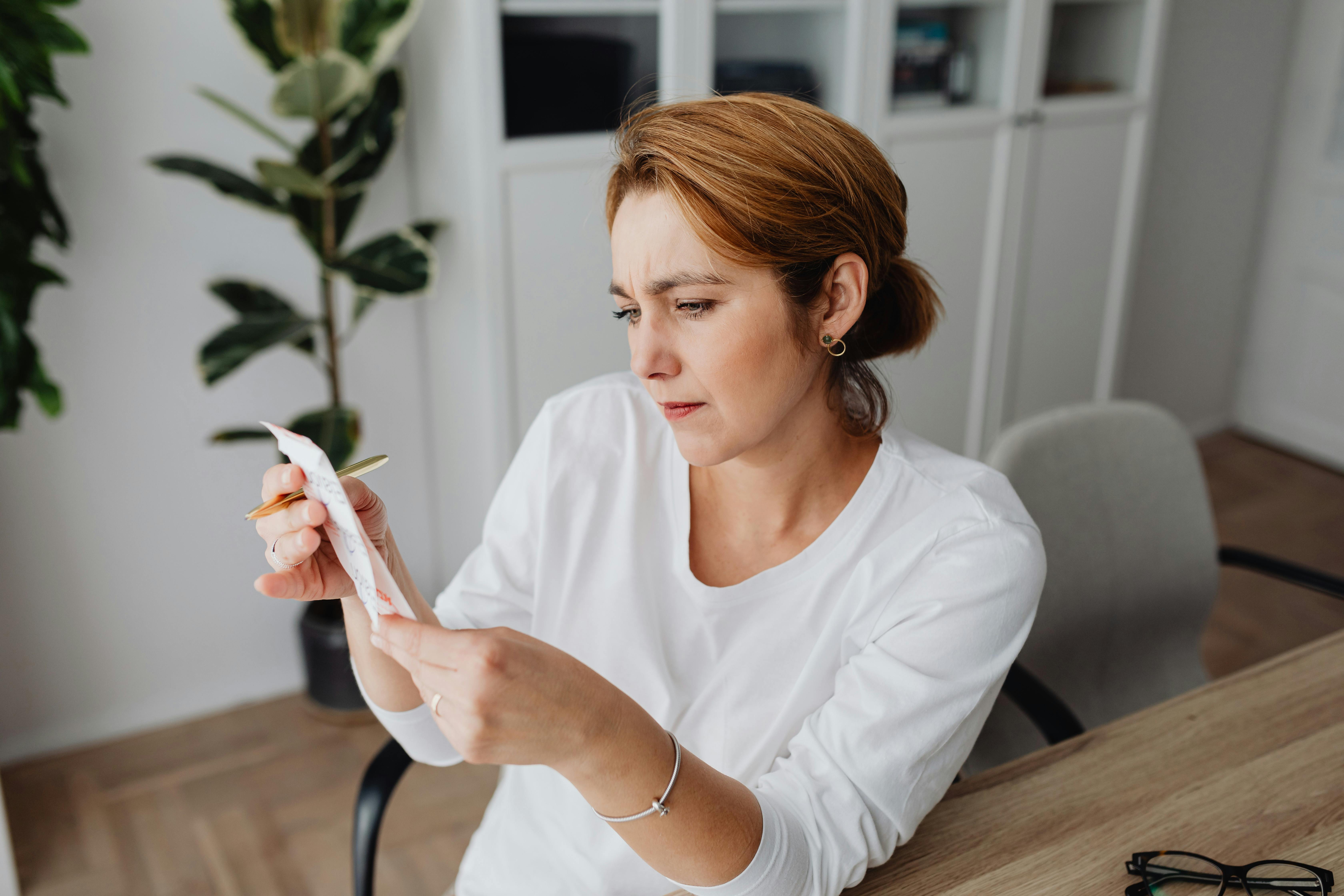 Une femme confuse qui regarde un reçu | Source : Pexels