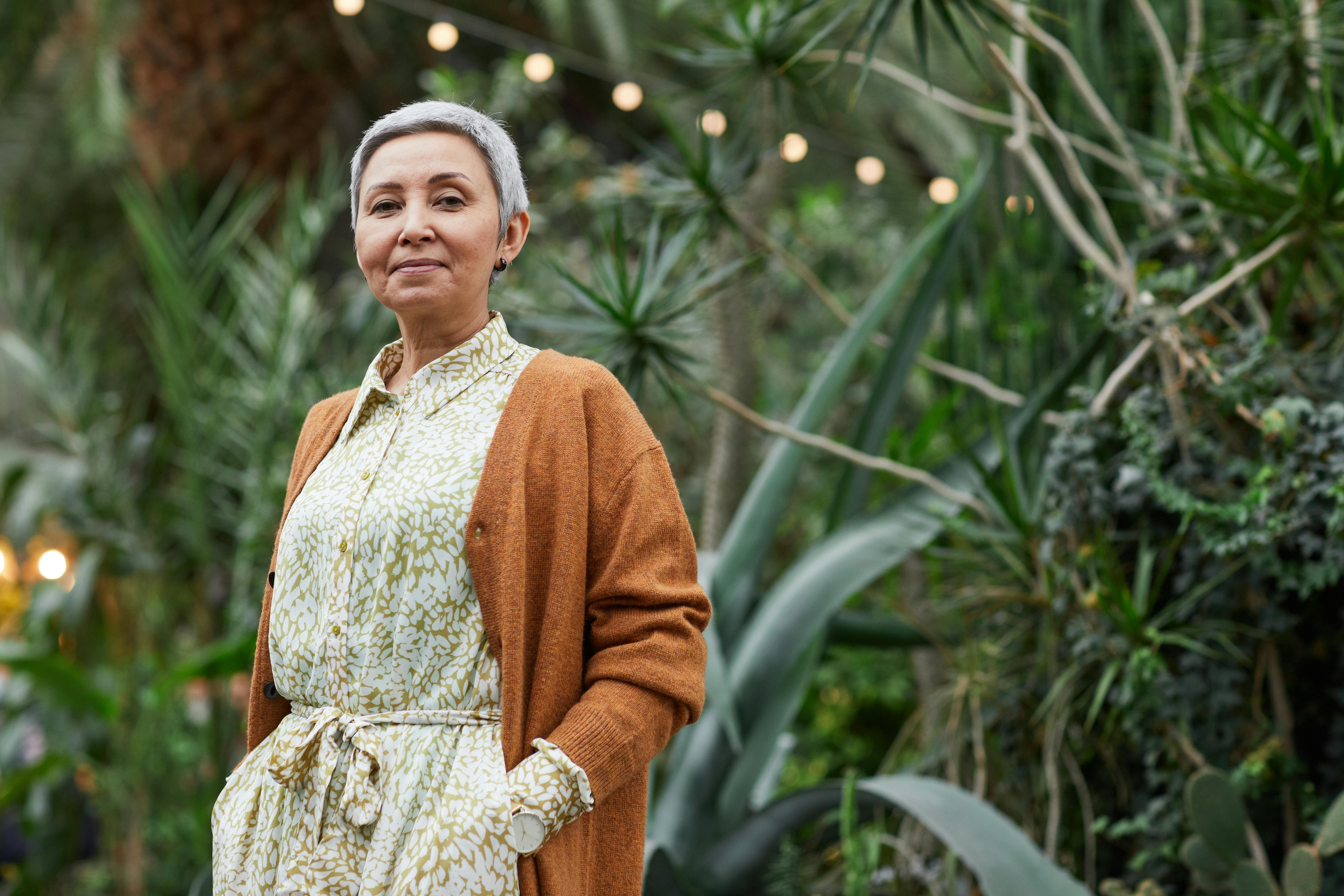 Une femme âgée souriante debout à l'extérieur | Source : Pexels