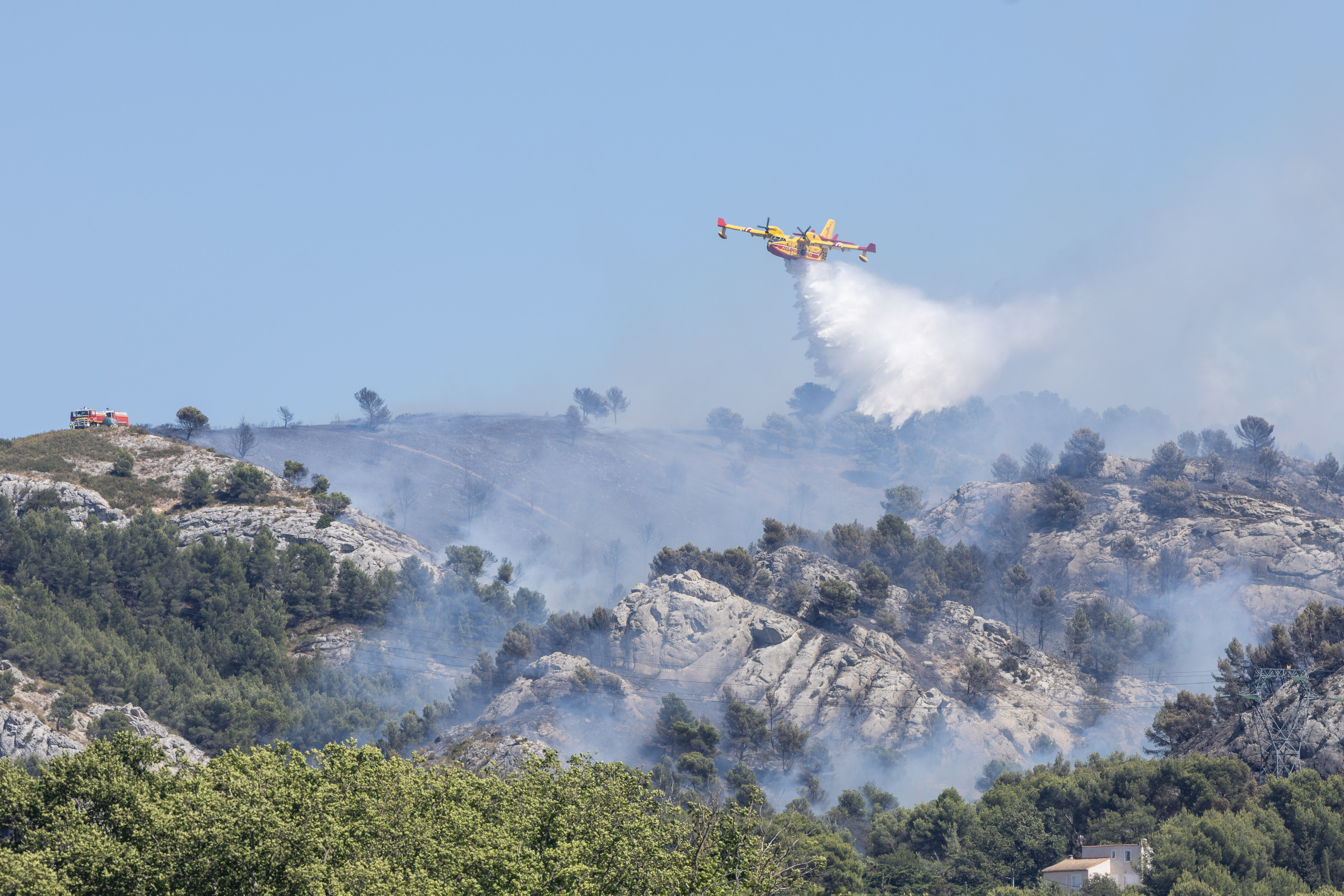 Un avion bombardier d'eau de type Canadair appartenant à la flotte nationale de sécurité civile intervient lors de l'incendie qui fait rage dans les collines au nord de Marseille, dans la région des Pennes-Mirabeau, le 8 juillet 2025 à Marseille, en France I Source : Getty Images