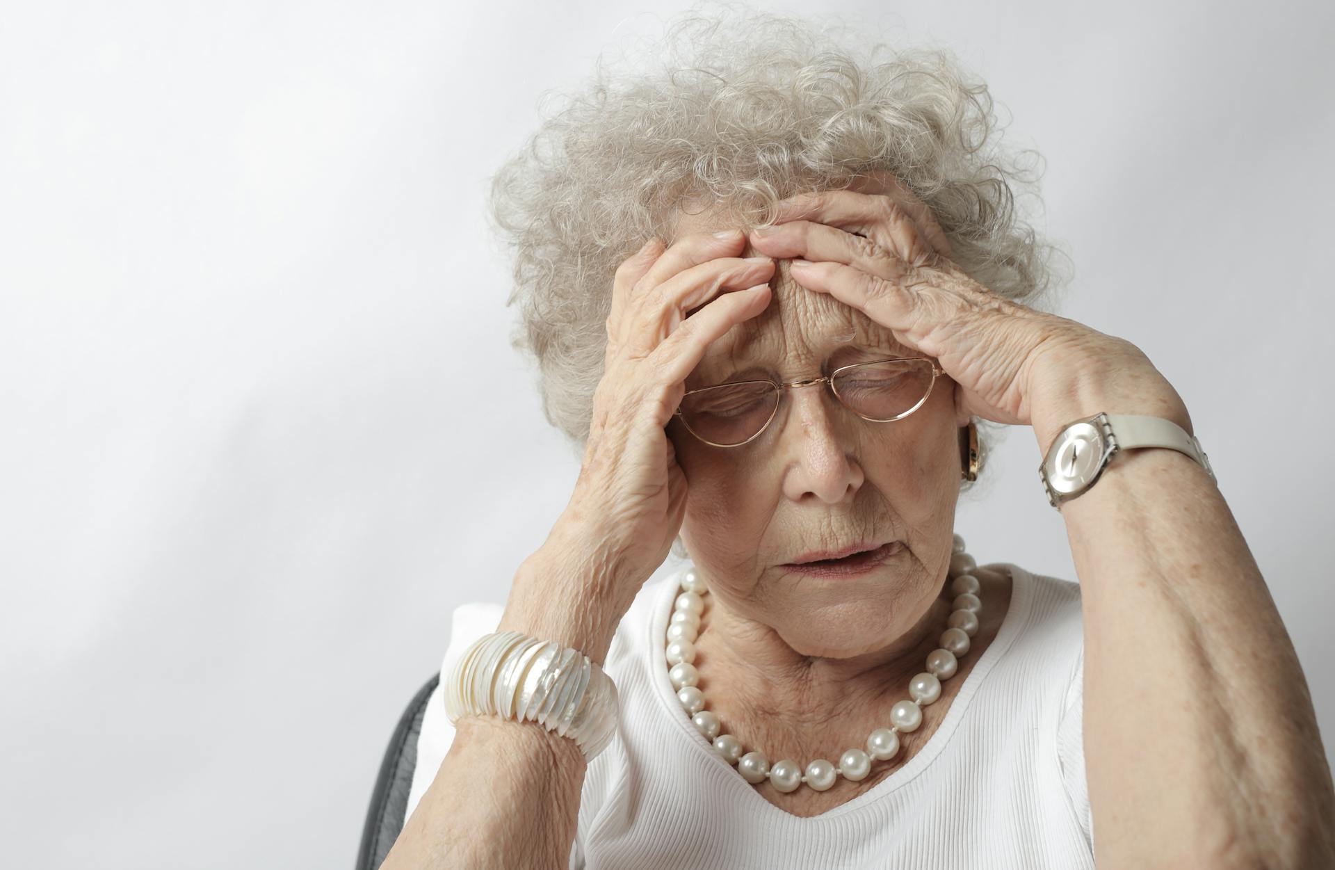 Une dame âgée en détresse se tenant la tête | Source : Pexels