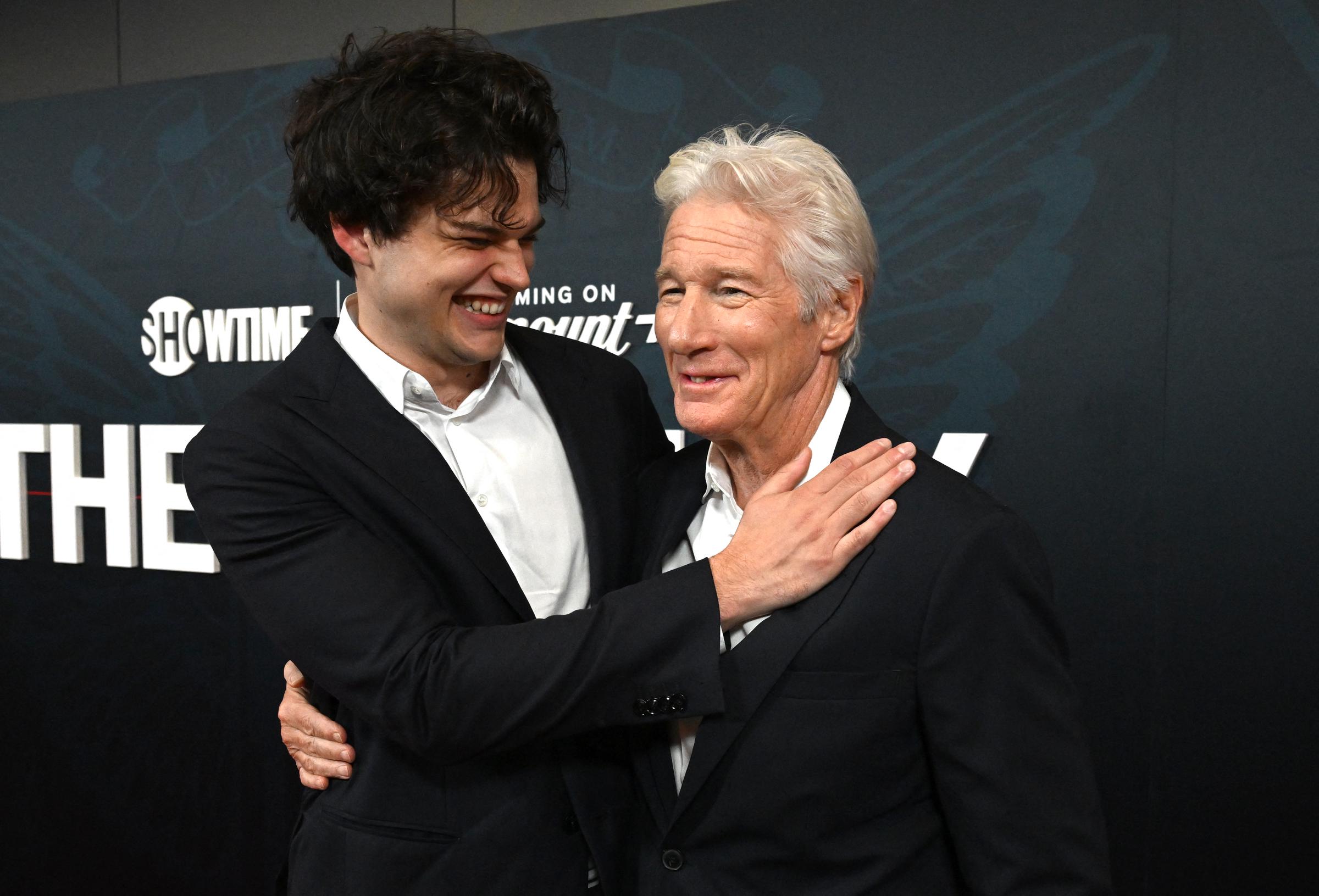 Homer Gere passe son bras autour des épaules de son père, Richard Gere, et partage un rire sincère lors de la première du film « The Agency » à New York. Le duo père-fils rayonne de chaleur et de charisme sur le tapis rouge.