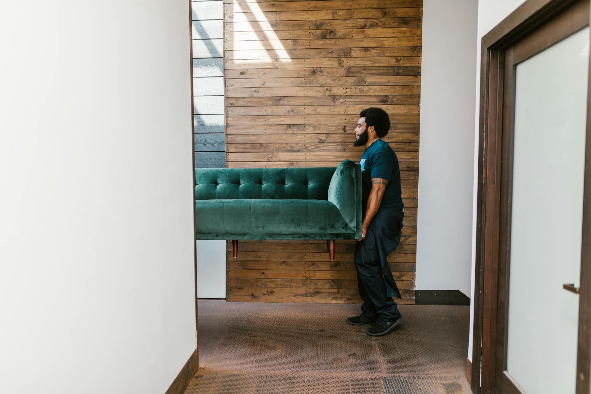 Un homme qui déplace un canapé | Source : Pexels