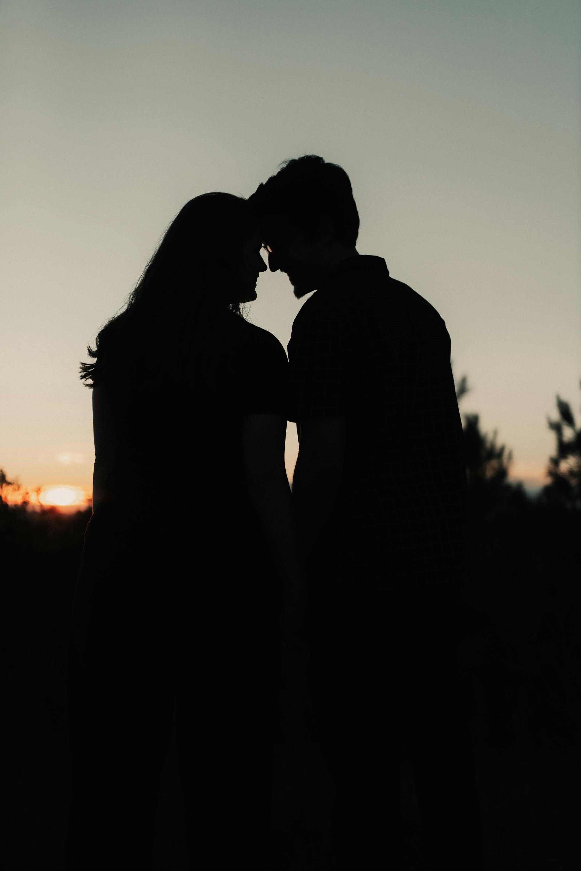 Silhouette d'un couple romantique au coucher du soleil | Source : Pexels