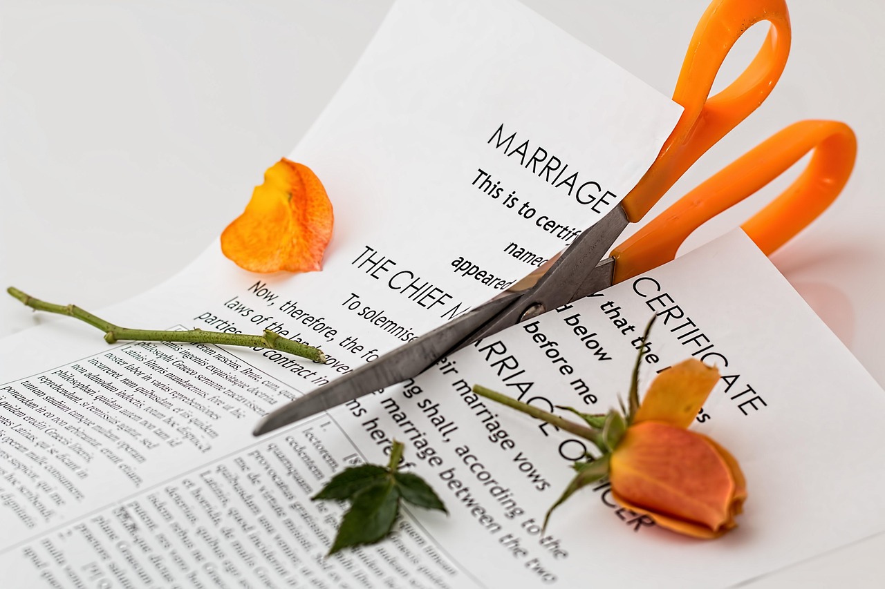 Un ciseau découpant un acte de mariage | Source : Pixabay
