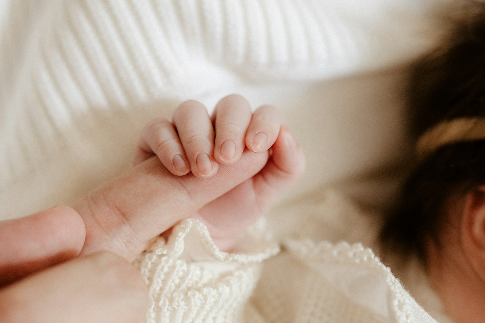 Un bébé tenant le doigt d'une personne | Source : Unsplash