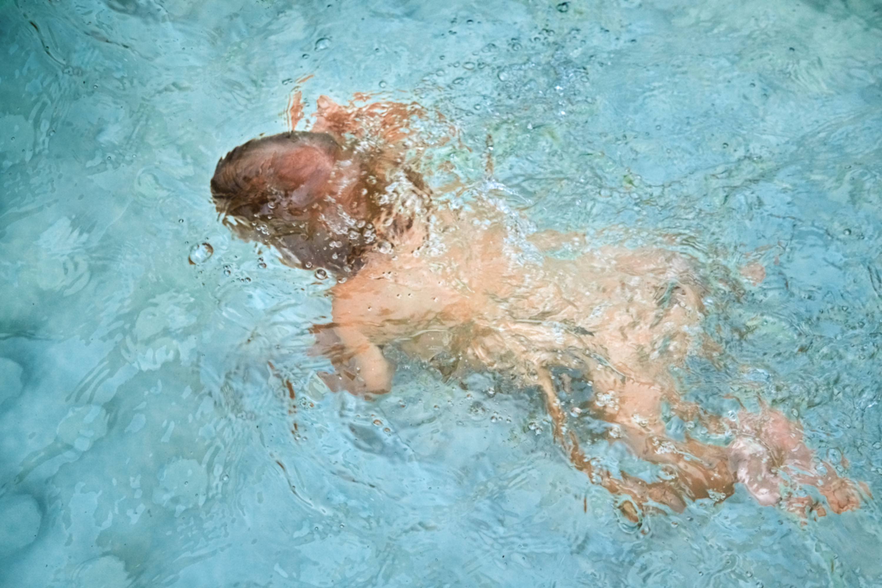 Vue d'en haut d'un bébé sous l'eau I Photo d'illustration I Source : Getty Images