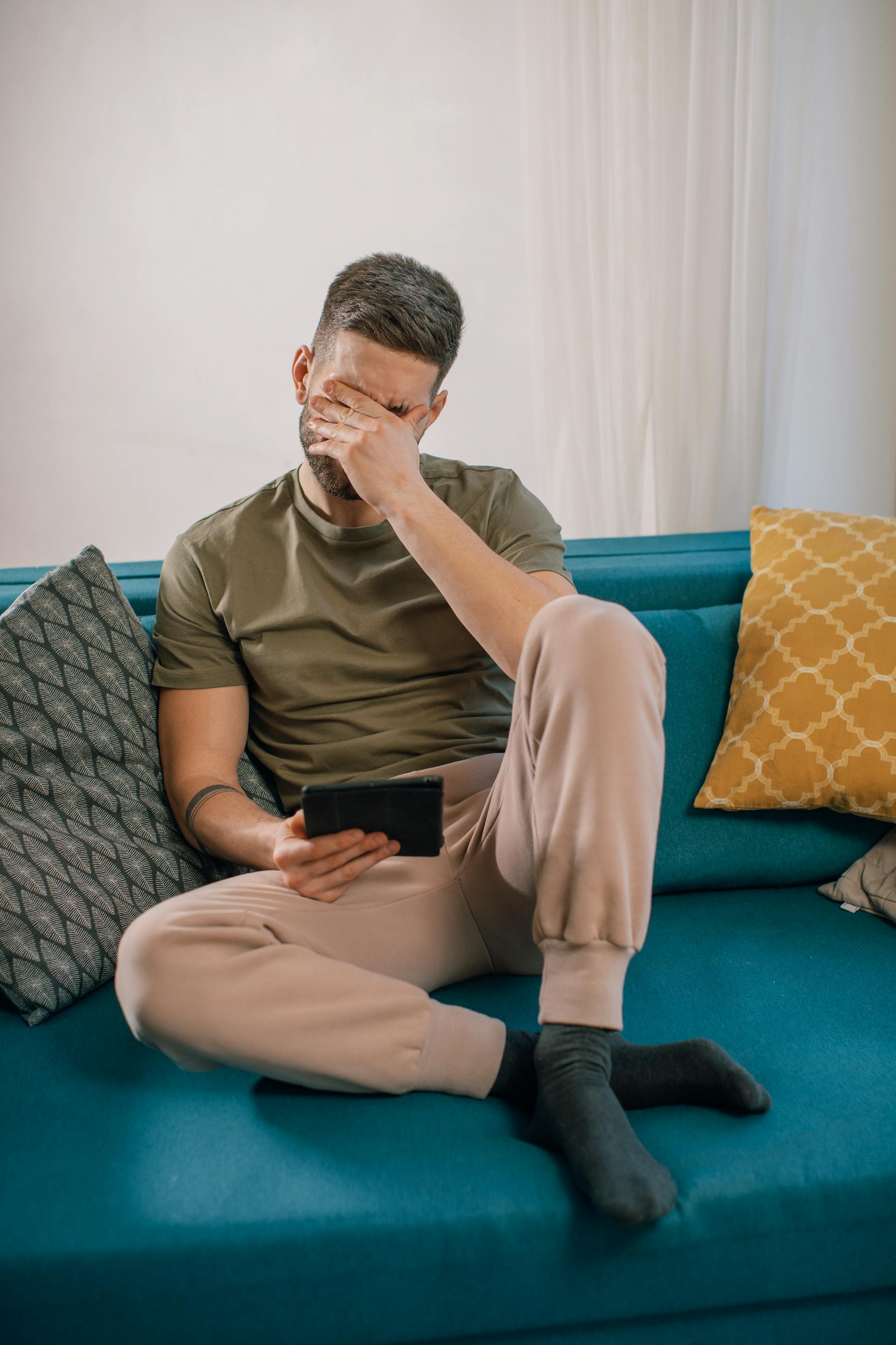 Un homme contrarié assis sur le canapé | Source : Pexels