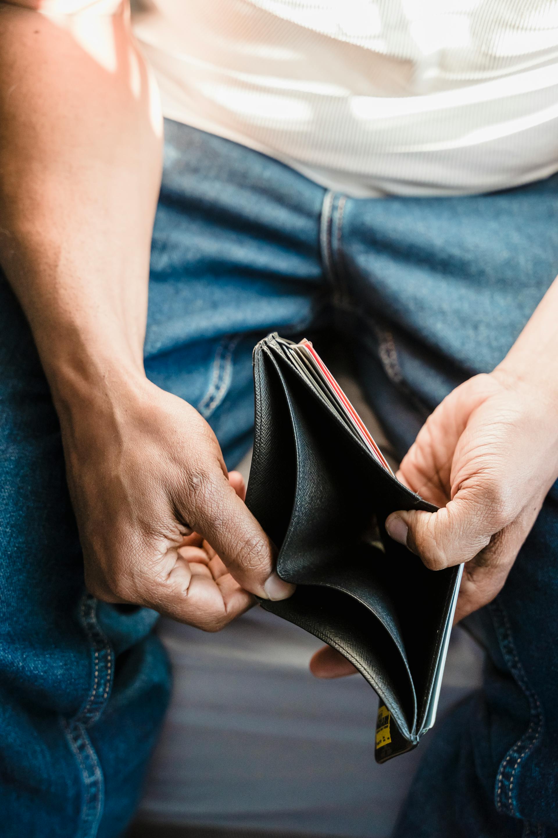 Un homme tenant son portefeuille | Source : Pexels