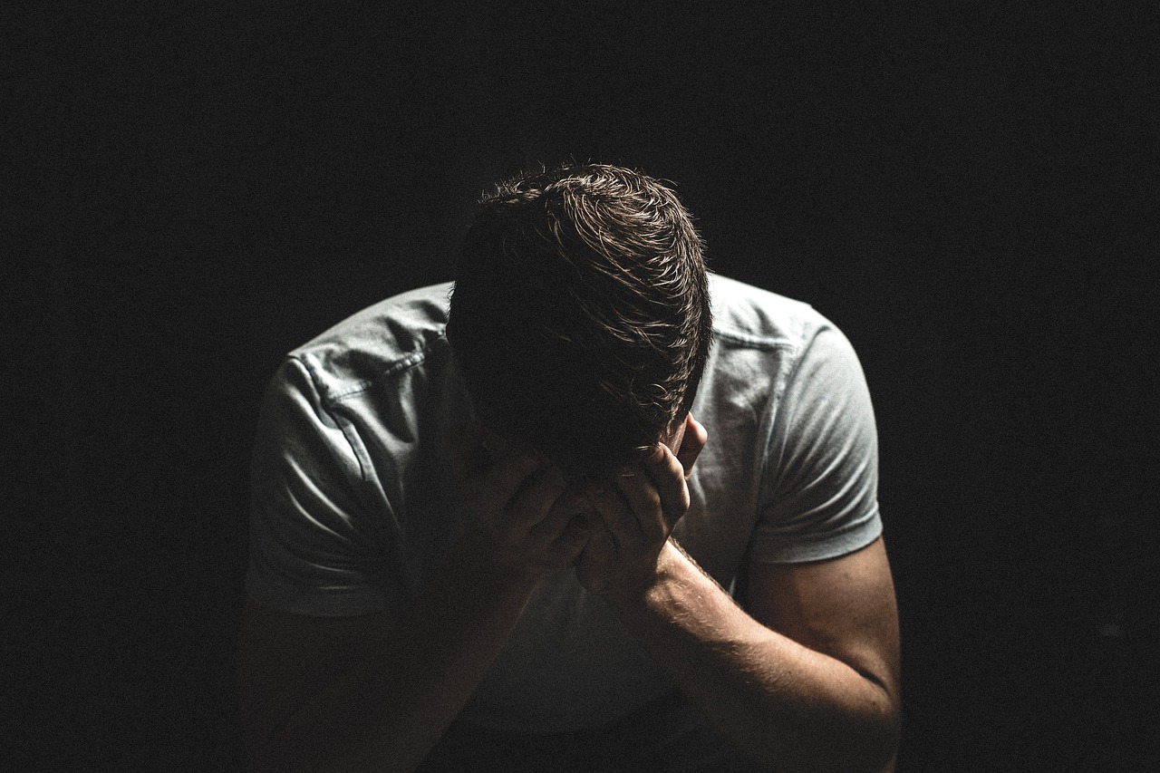 Un homme triste qui enfouit son visage dans ses mains | Source : Pixabay