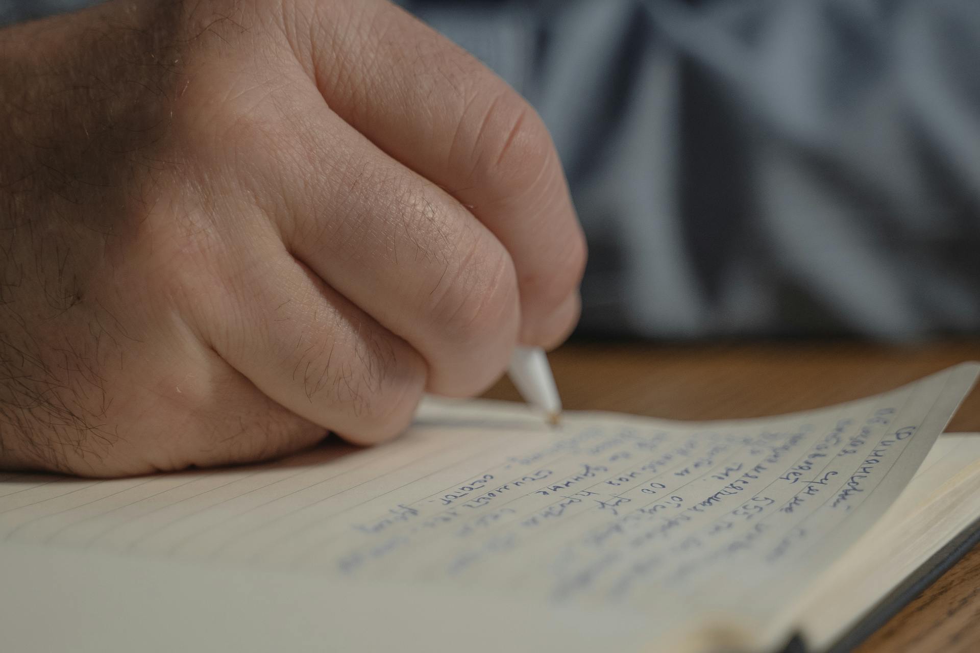 Une personne qui écrit sur du papier | Source : Pexels