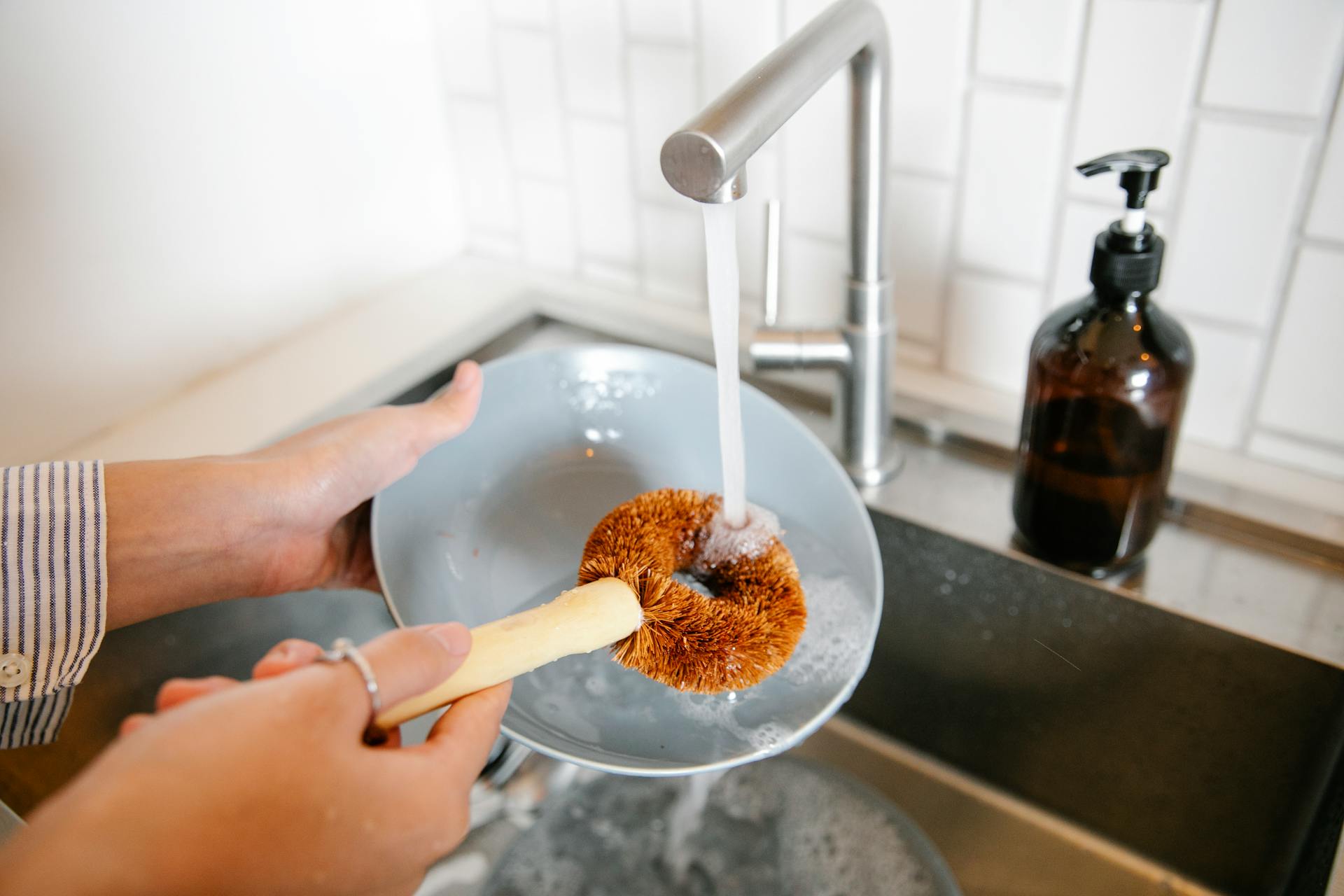 Gros plan sur une femme qui fait la vaisselle dans la cuisine | Source : Pexels