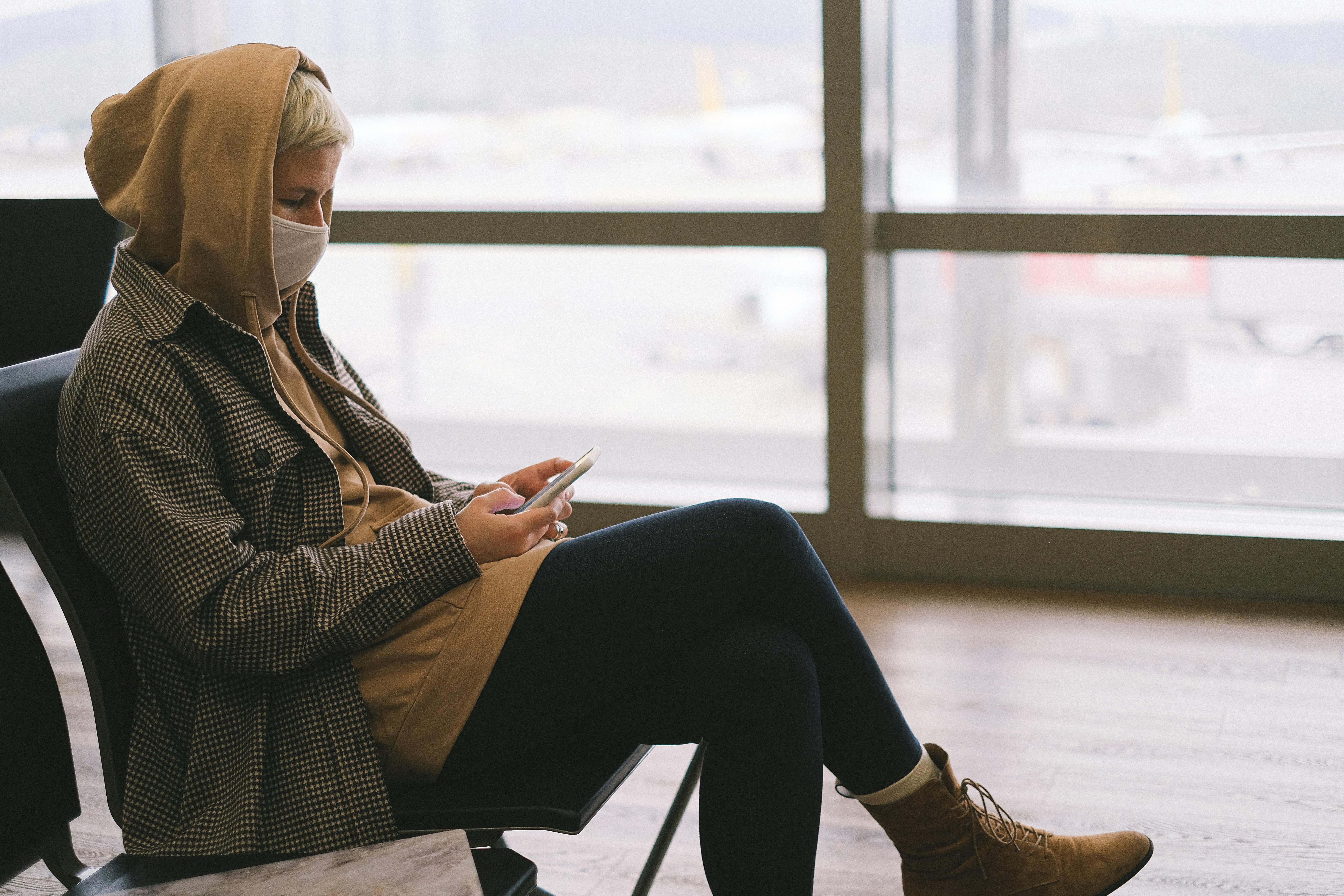 Une femme utilisant son téléphone dans un aéroport | Source : Pexels