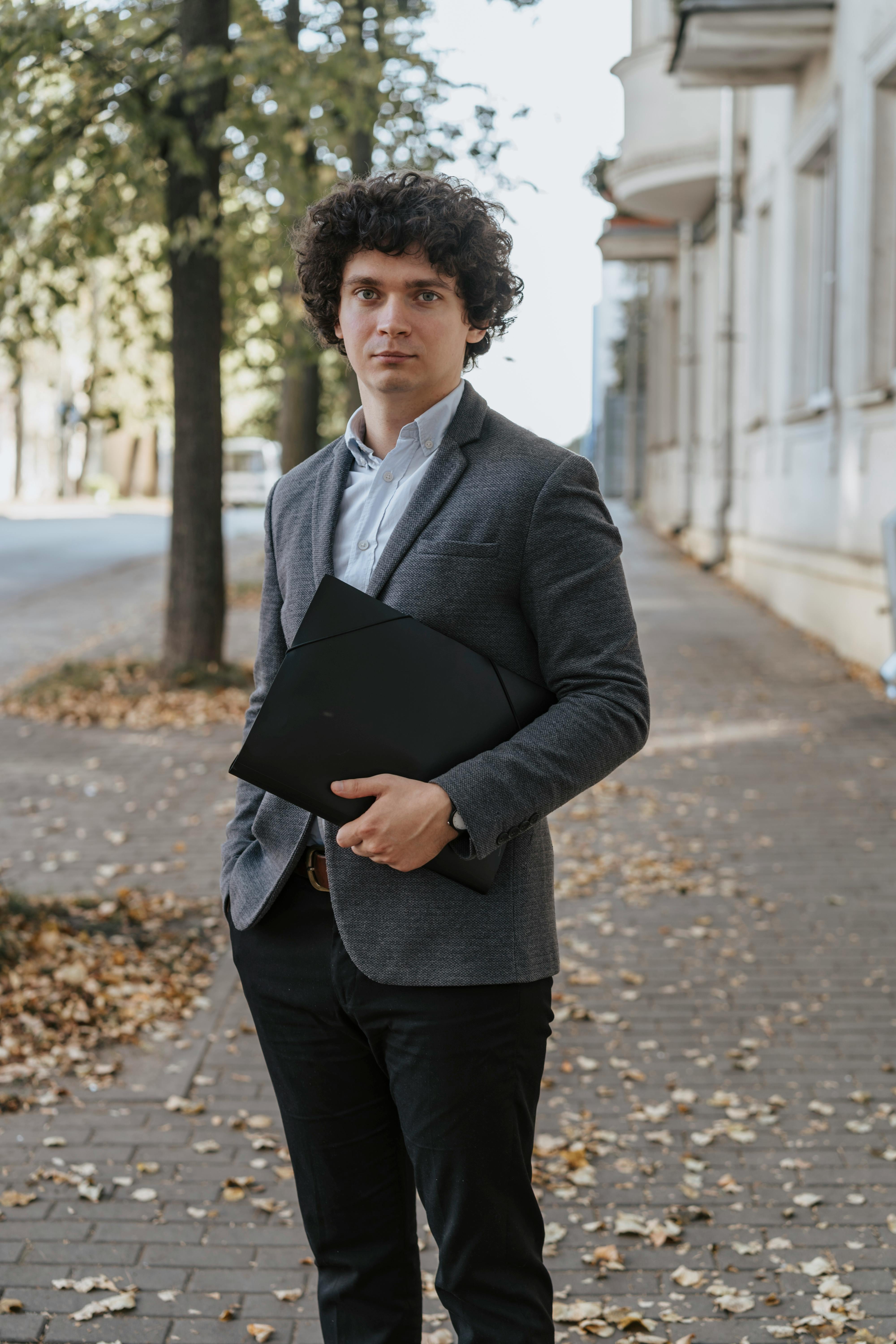 Un homme tenant un dossier en cuir | Source : Pexels