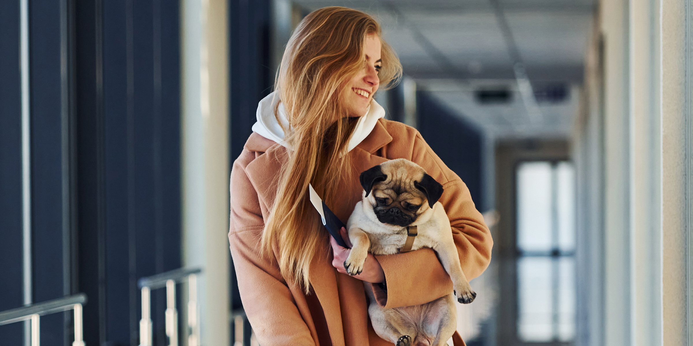 Une femme souriante avec un petit chien | Source : Shutterstock