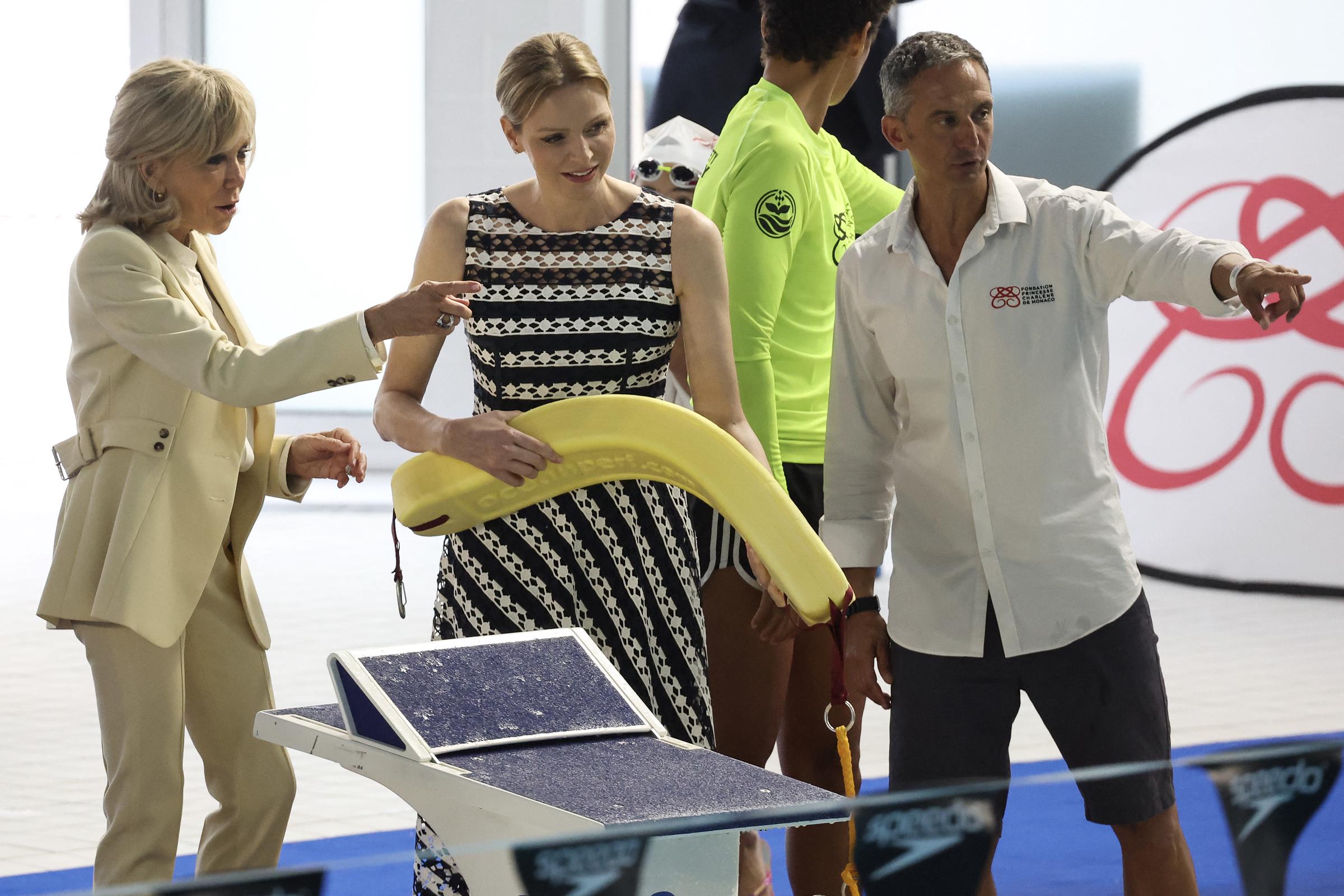 La première dame de France Brigitte Macron (G) et la princesse Charlène de Monaco (C) assistent à la démonstration "Sécurité aquatique" lors d'une visite au "Centre nautique Albert II", dans le cadre d'un événement organisé par la Fondation Princesse Charlène, à Monaco, le 8 juin 2025 I Source : Getty Images