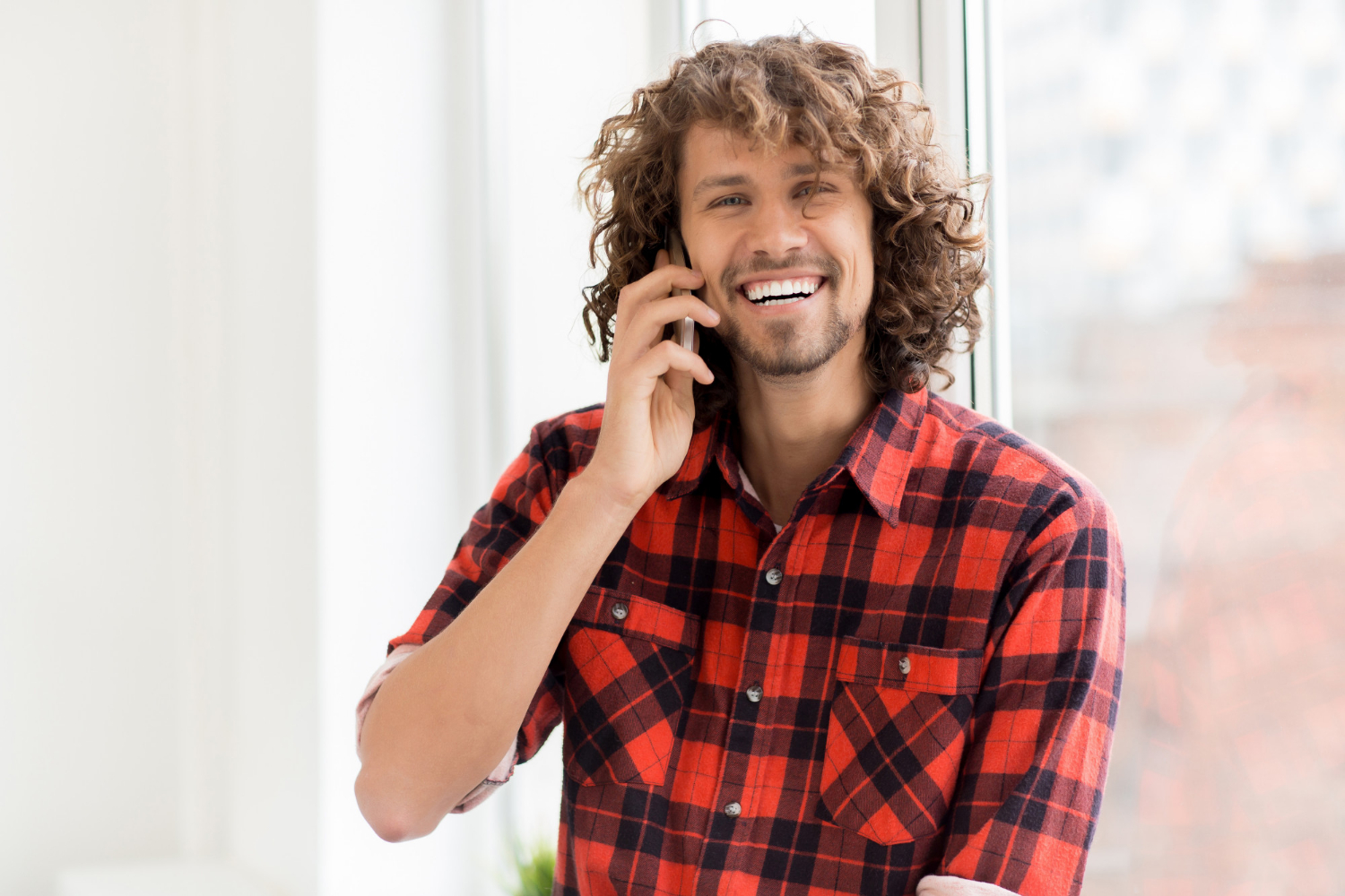 Un homme rieur qui parle au téléphone | Source : Freepik
