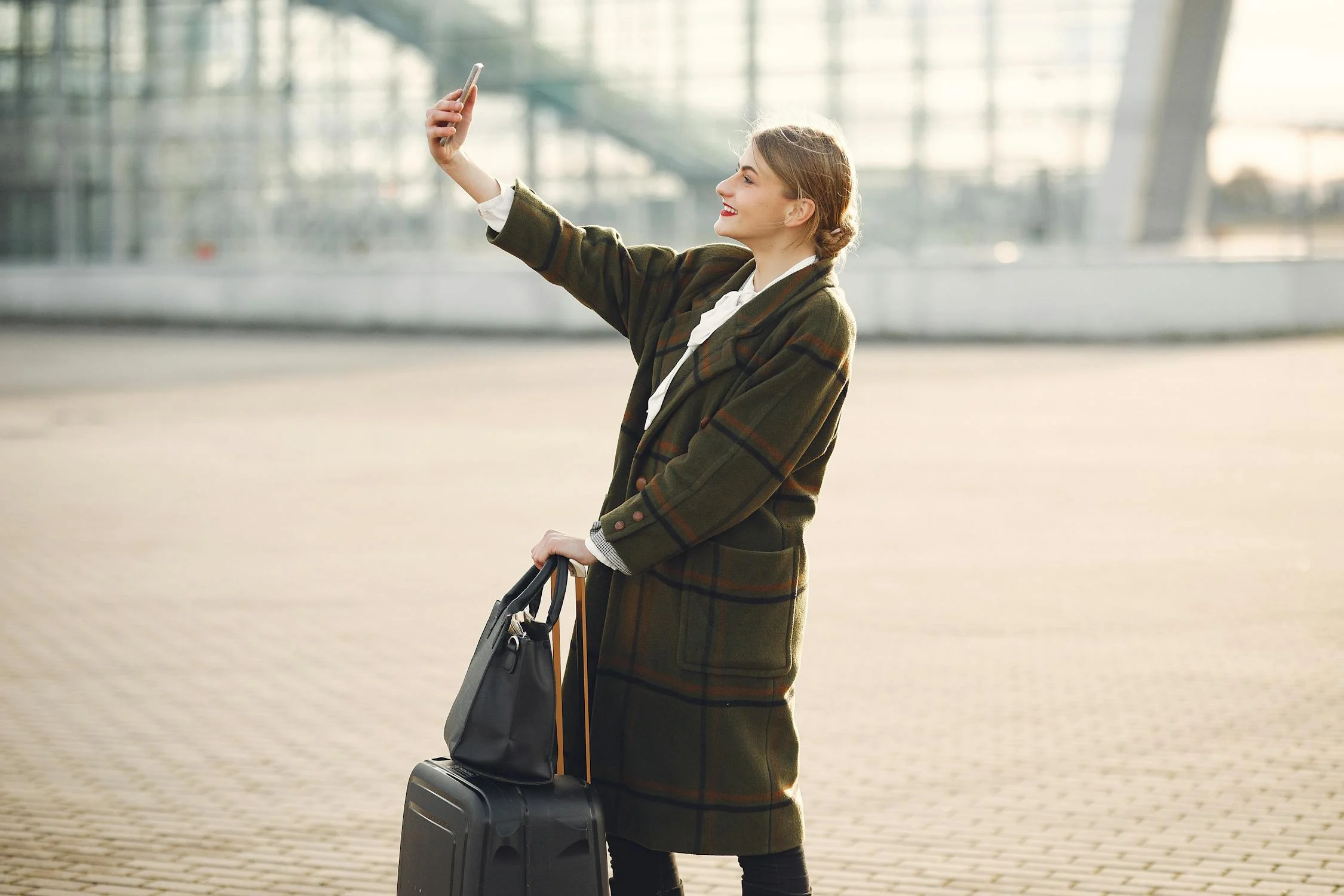 Une femme avec son téléphone dans un aéroport | Source : Pexels