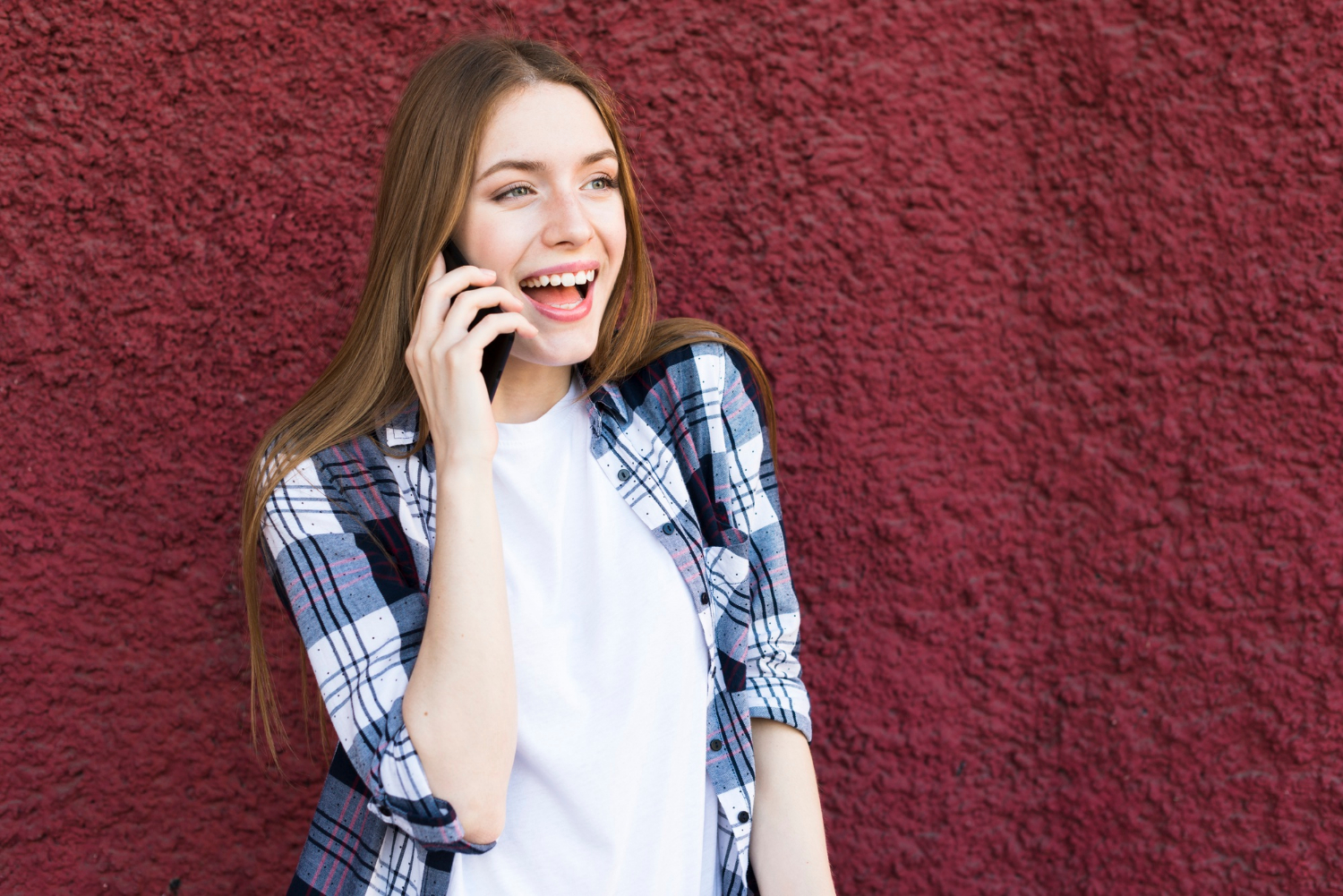 Une femme joyeuse qui parle au téléphone | Source : Freepik