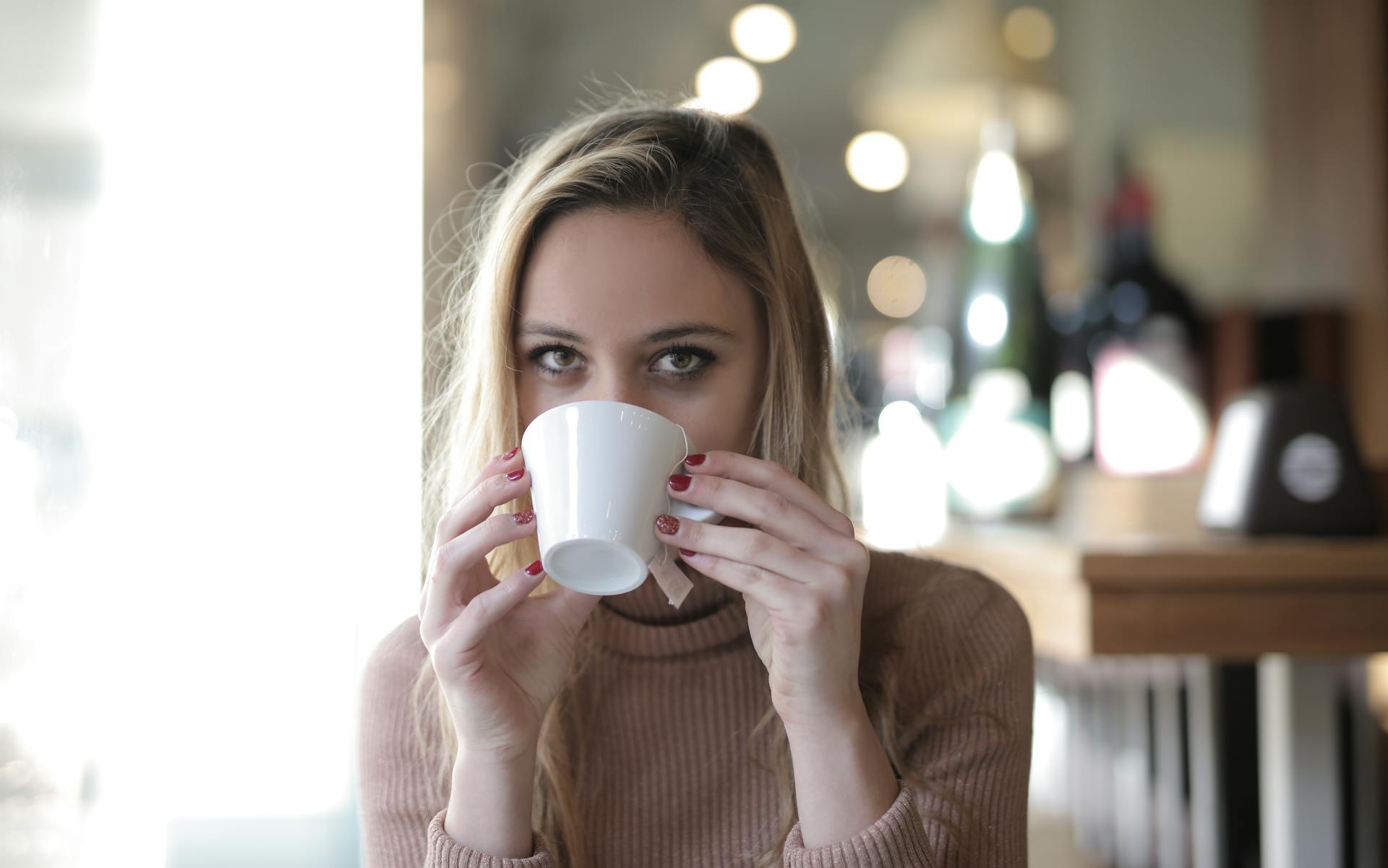 Une femme qui boit dans une tasse | Source : Pexels