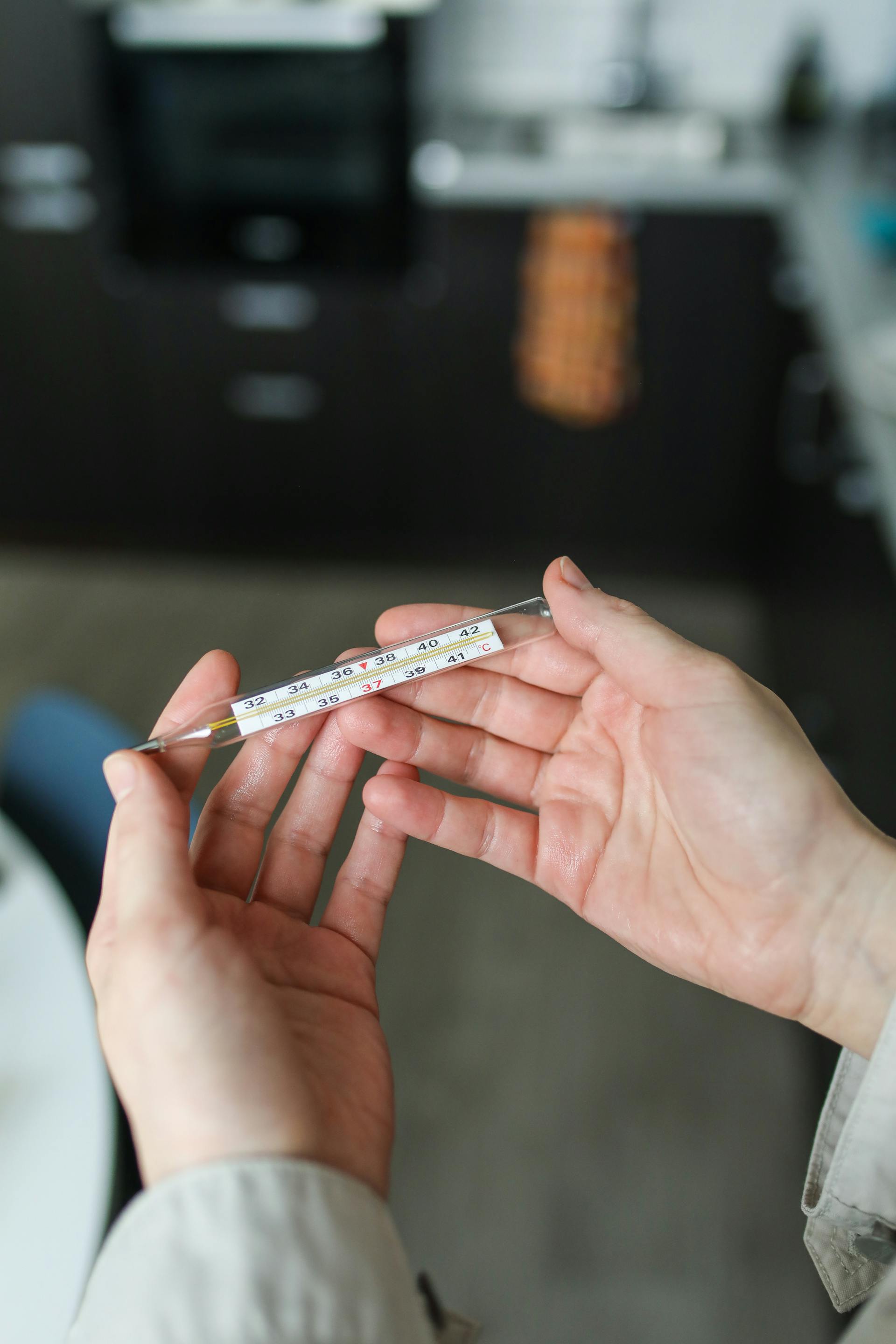 Une personne tenant un thermomètre | Source : Pexels