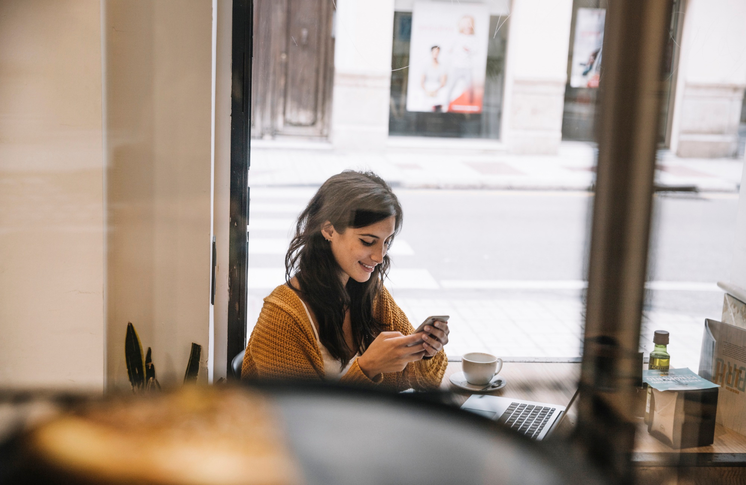 Une femme qui regarde son téléphone et sourit | Source : Freepik