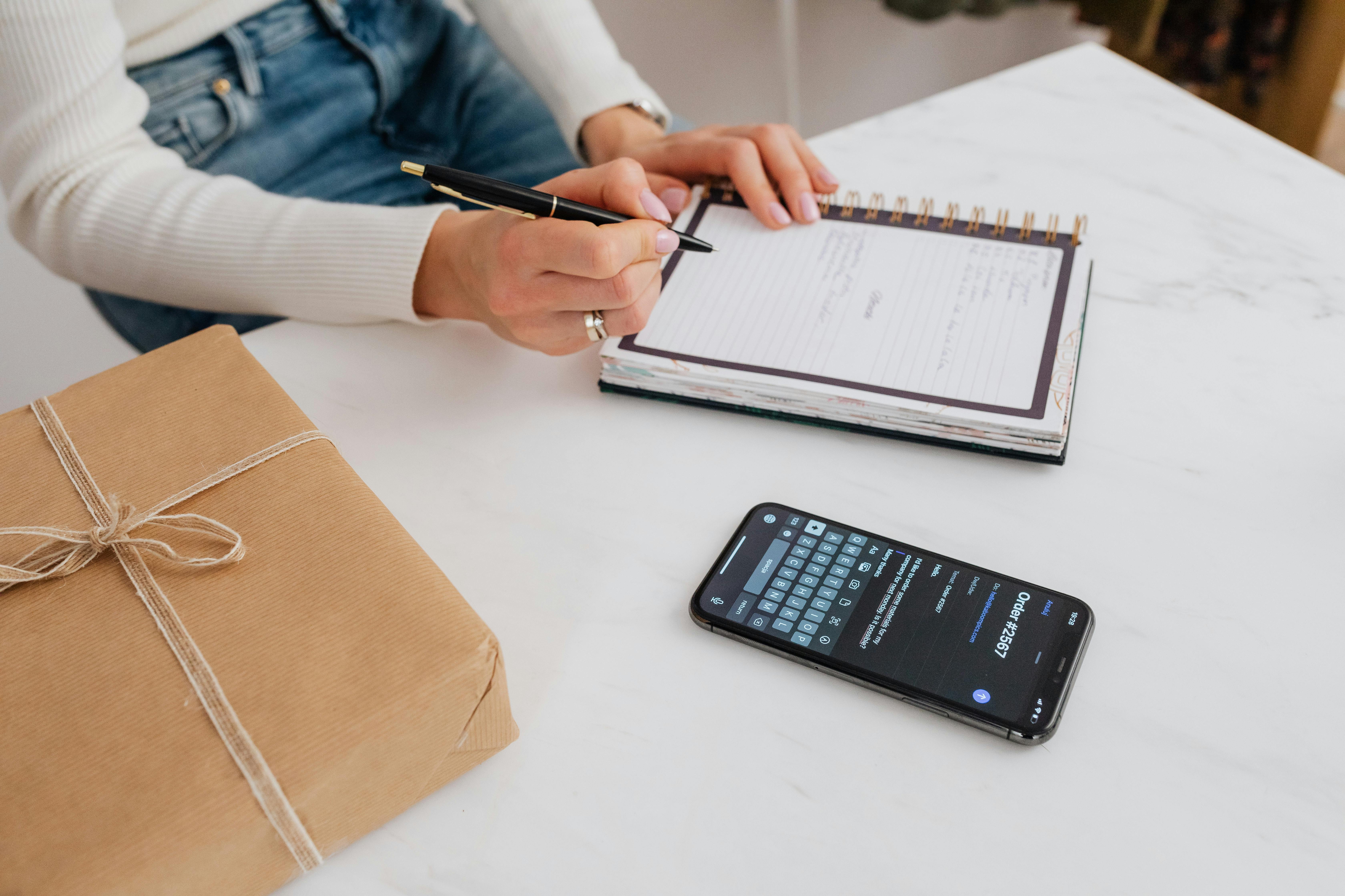 Une personne qui écrit sur un cahier blanc | Source : Pexels