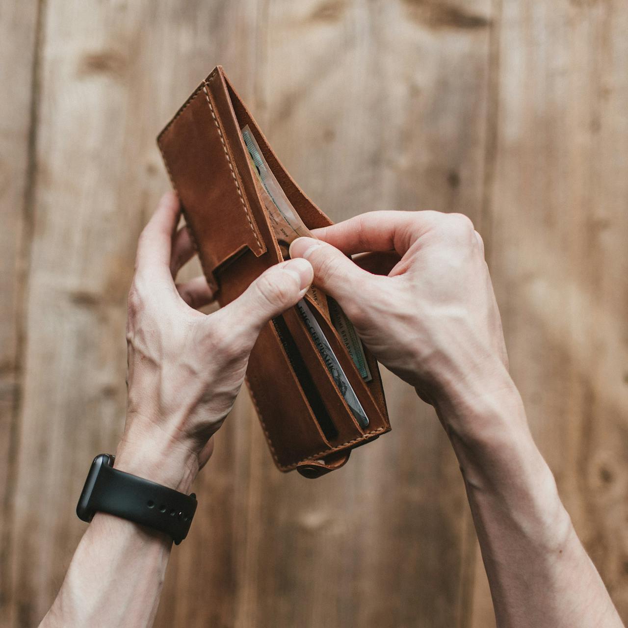 Un homme tenant son portefeuille | Source : Pexels
